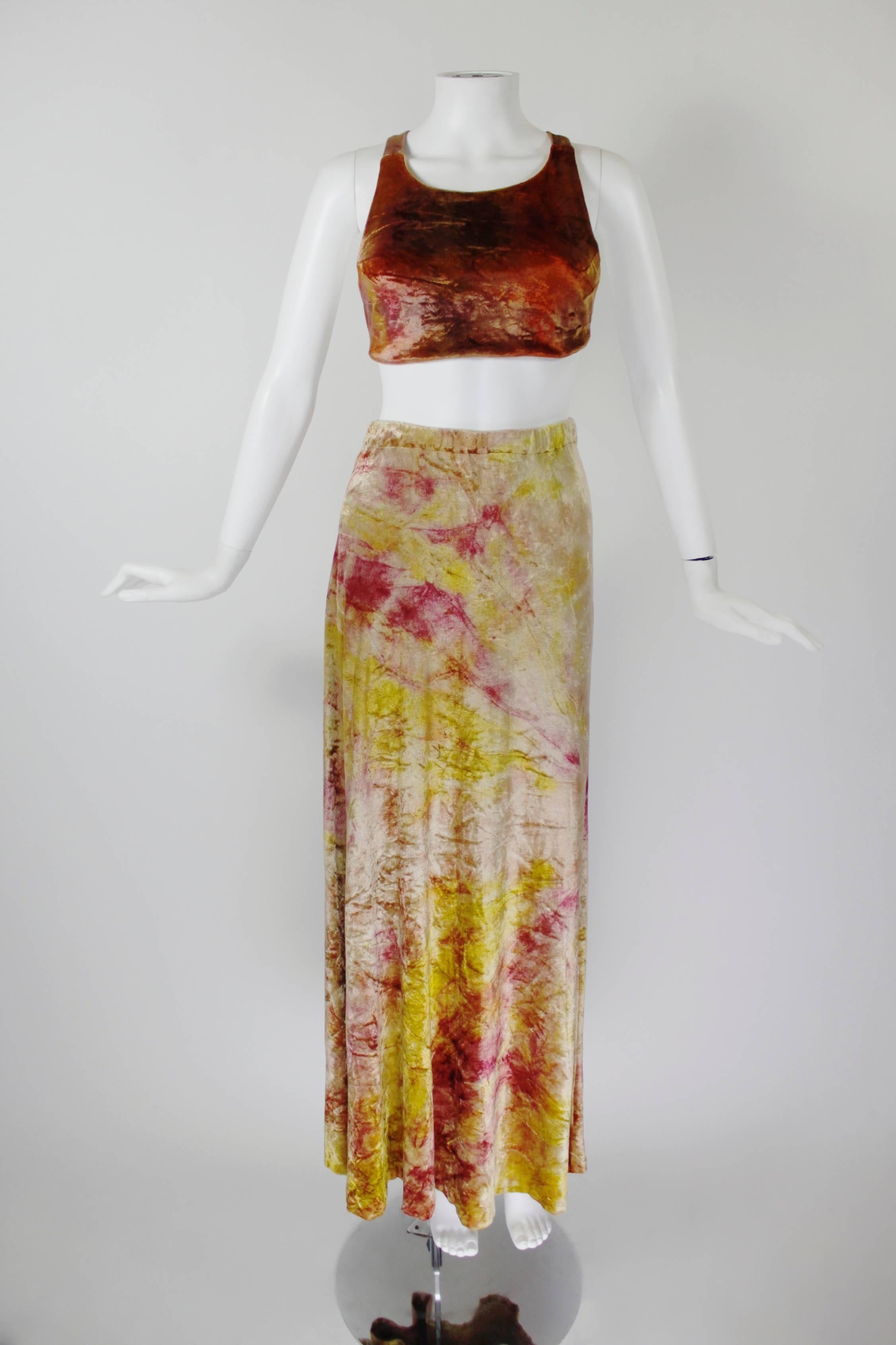Renowned for its iconic boho pieces, this ensemble is a wonderful example of the gorgeous work Holly's Harp produced. A criss-cross back crop top and matching slightly flared maxi skirt are done in orange, red, yellow, and blush tie-dyed velvet.