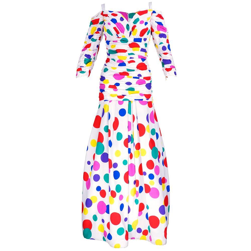 Off the shoulder rainbow polka dot silk gown from Arnold Scaasi. Sleeves and drop waisted bodice are gathered and hand tacked. Skirt is gently pleated at drop waist for fullness. Tulle and horsehair petticoat attached to add structure and