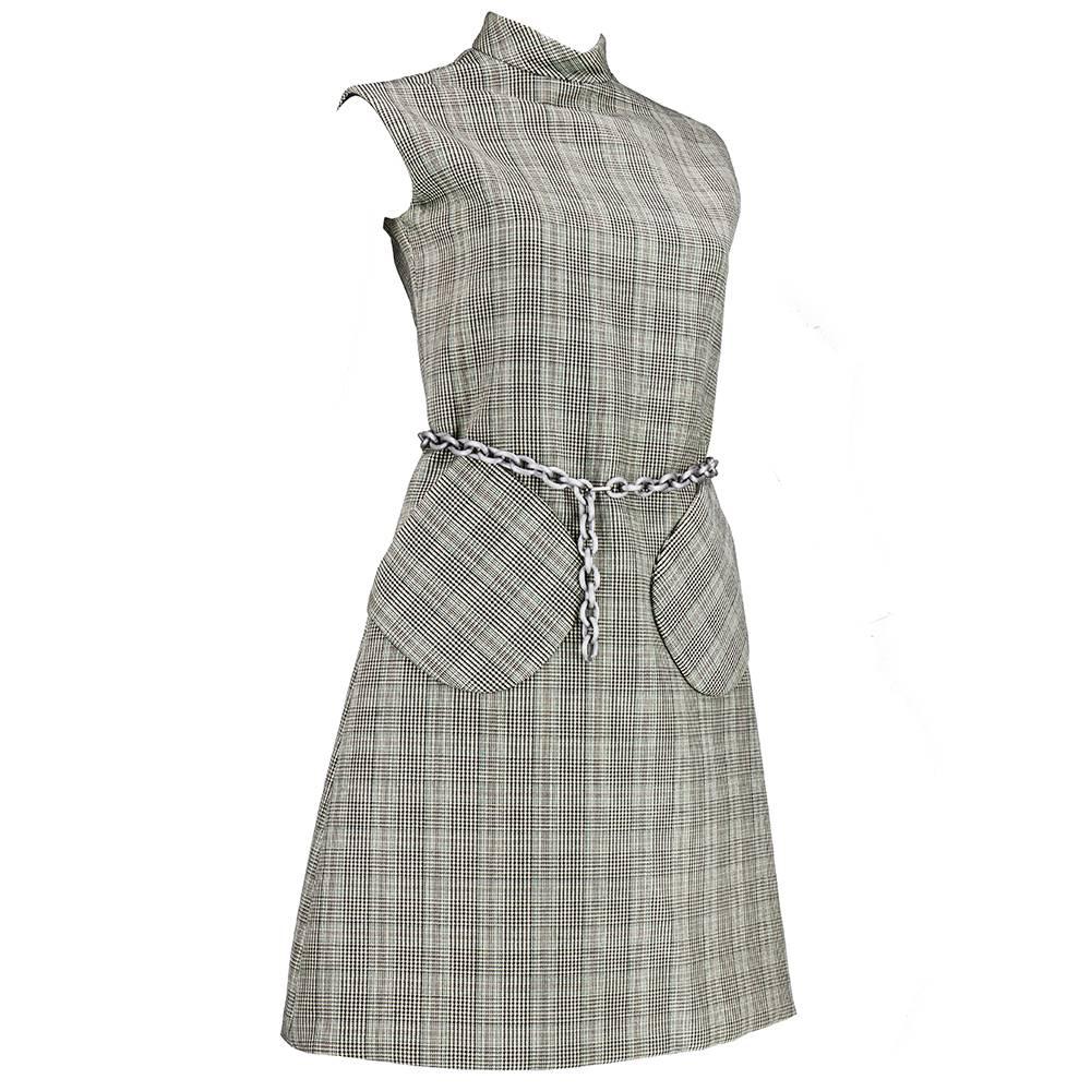 Classic styling from great American designer Bill Blass. Black and grey wool houndstooth. Slightly A line with high collar and large patch pockets. Lightweight chain link belt. 