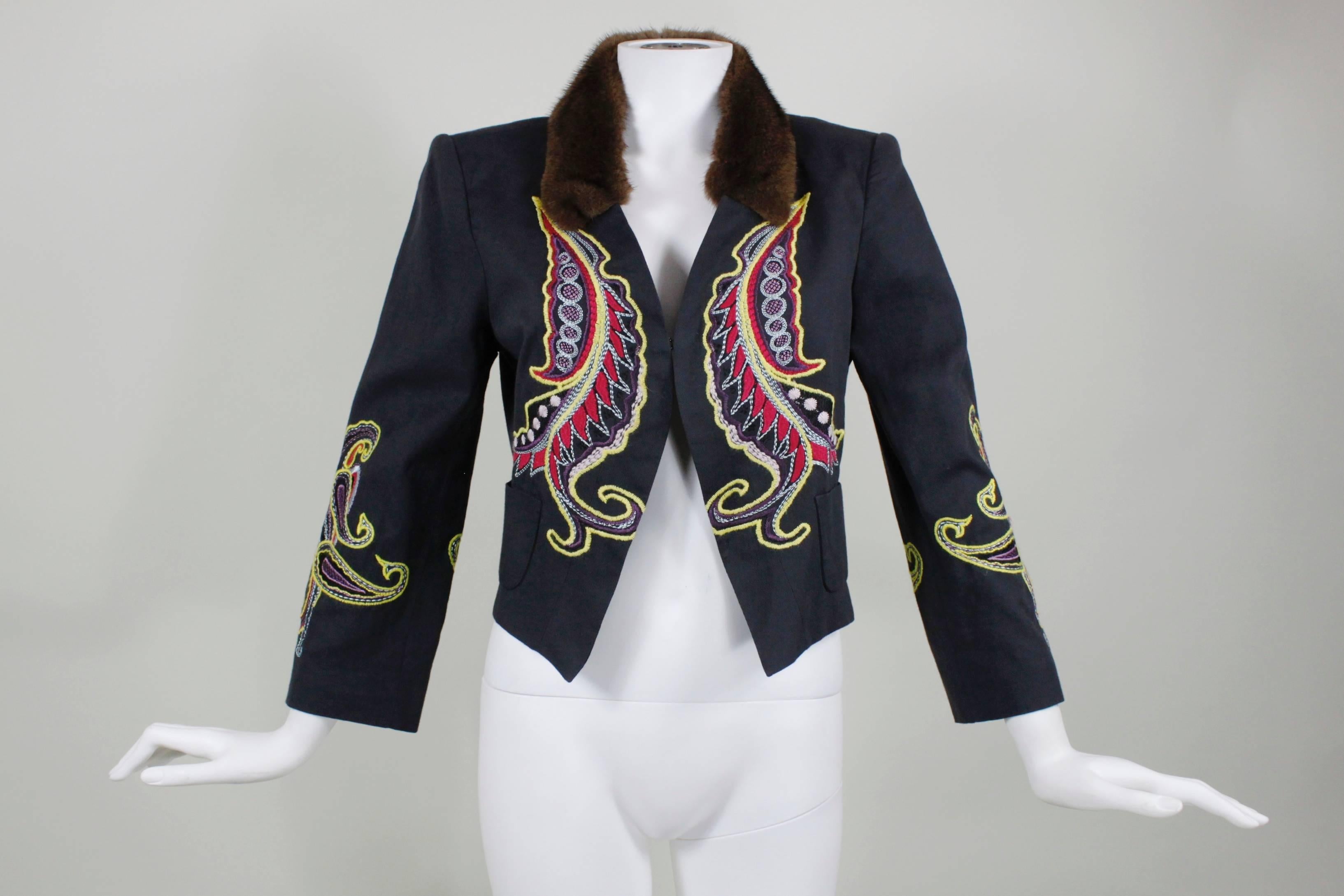A fabulous lightweight cotton-wool jacket from Christian Lacroix. Done in dark navy blue wool, the jacket features vibrant red, yellow, and cornflower embroidery throughout. A fresh fur collar trims the jacket. Fully lined in colorful paisley