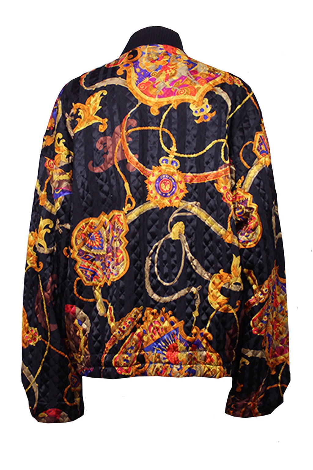 This jacket sports an outstanding gold tone baroque pattern on a black-on-black stripe background. The silhouette is an oversized bomber style with a wool knit collar and buttons at the wrist.