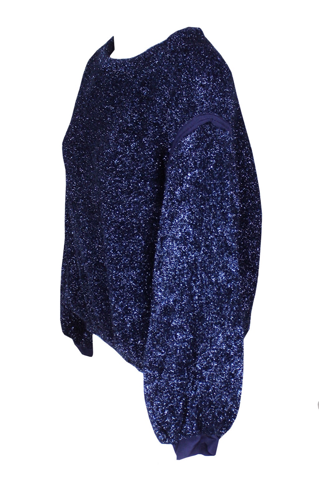 This festive crinkly sweater has a metallic finish in a deep blue hue. It has an elasticized waist and full elasticized sleeves with a knit cuff. This sweater is a fun garment that could work with jeans or be dressed up.