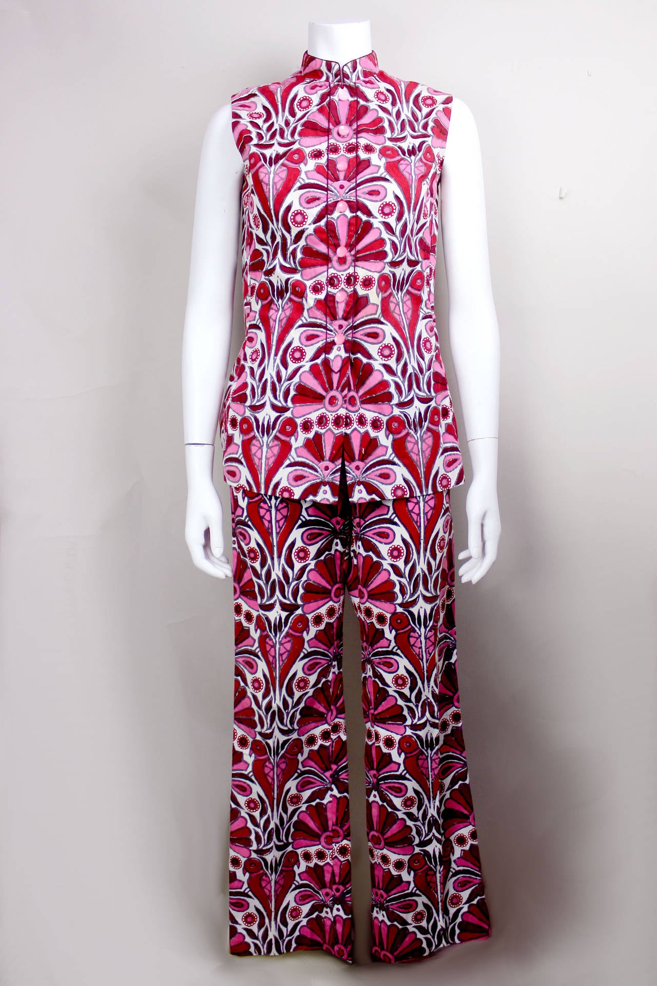This two-piece ensemble was made in the Bahamas in the early 1970s, when a visitor to the Caribbean could have a custom garment designed and sewn in 48 hours. It features a tropical batik print in a vibrant pink and wine on a white background. The