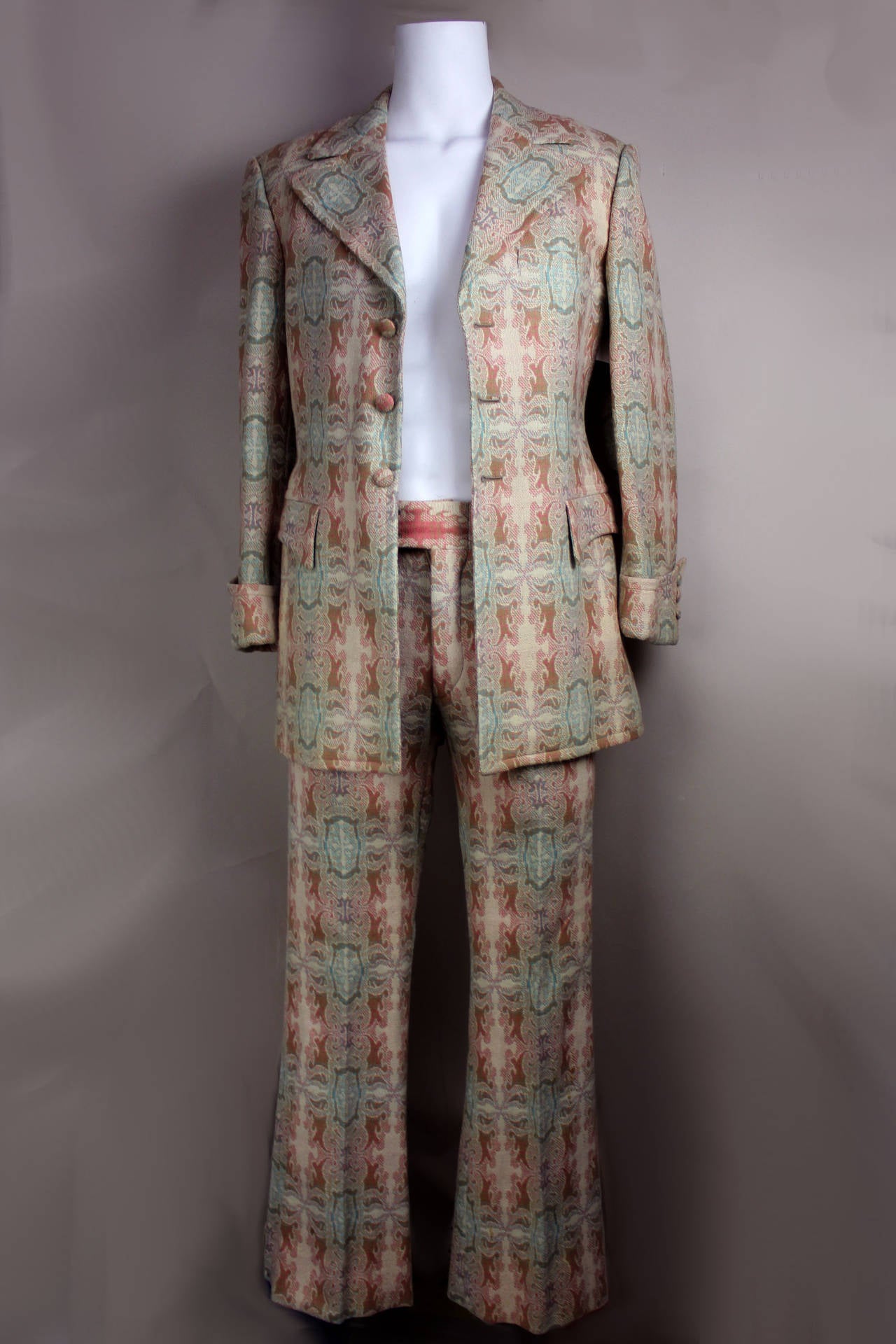 This suit came from the well known shop in the 1960's The Village Squire, NYC's version of the famous Carnaby Street boutiques. It is very handsomely done in soft mint, orange, and camel hues. This fabric is a wool brocade in an Edwardian pattern,