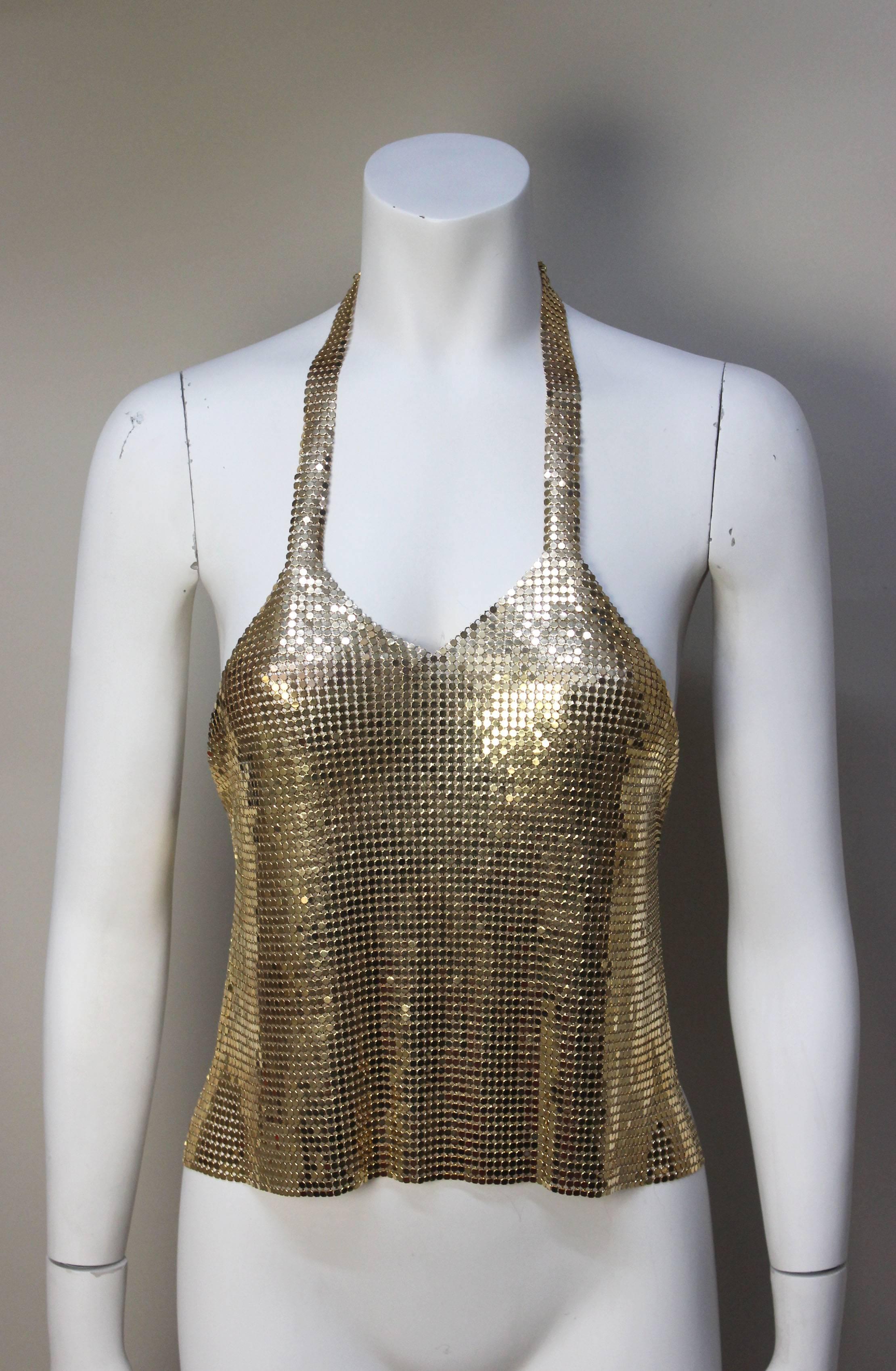 This sexy gold chain mesh top is an original from the 1970's. It's the quintessential disco era garment. It drapes fluidly across the front of the body, held in place by a chain halter top and a chain across the bare back. 