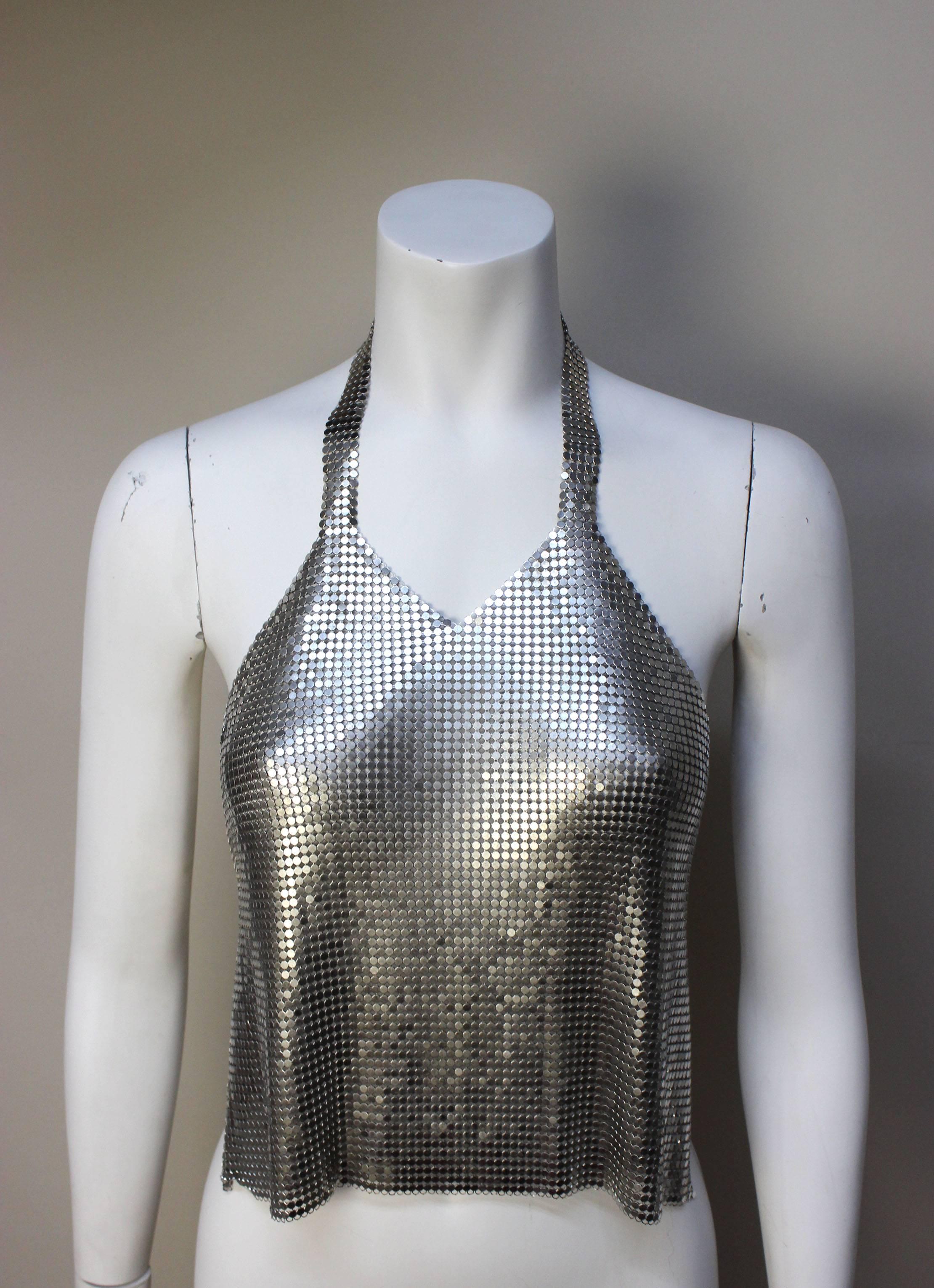 This sexy silver chain mesh top is an original from the 1970's. It's the quintessential disco era garment. It drapes fluidly across the front of the body, held in place by a chain halter top & a chain across the bare back. 