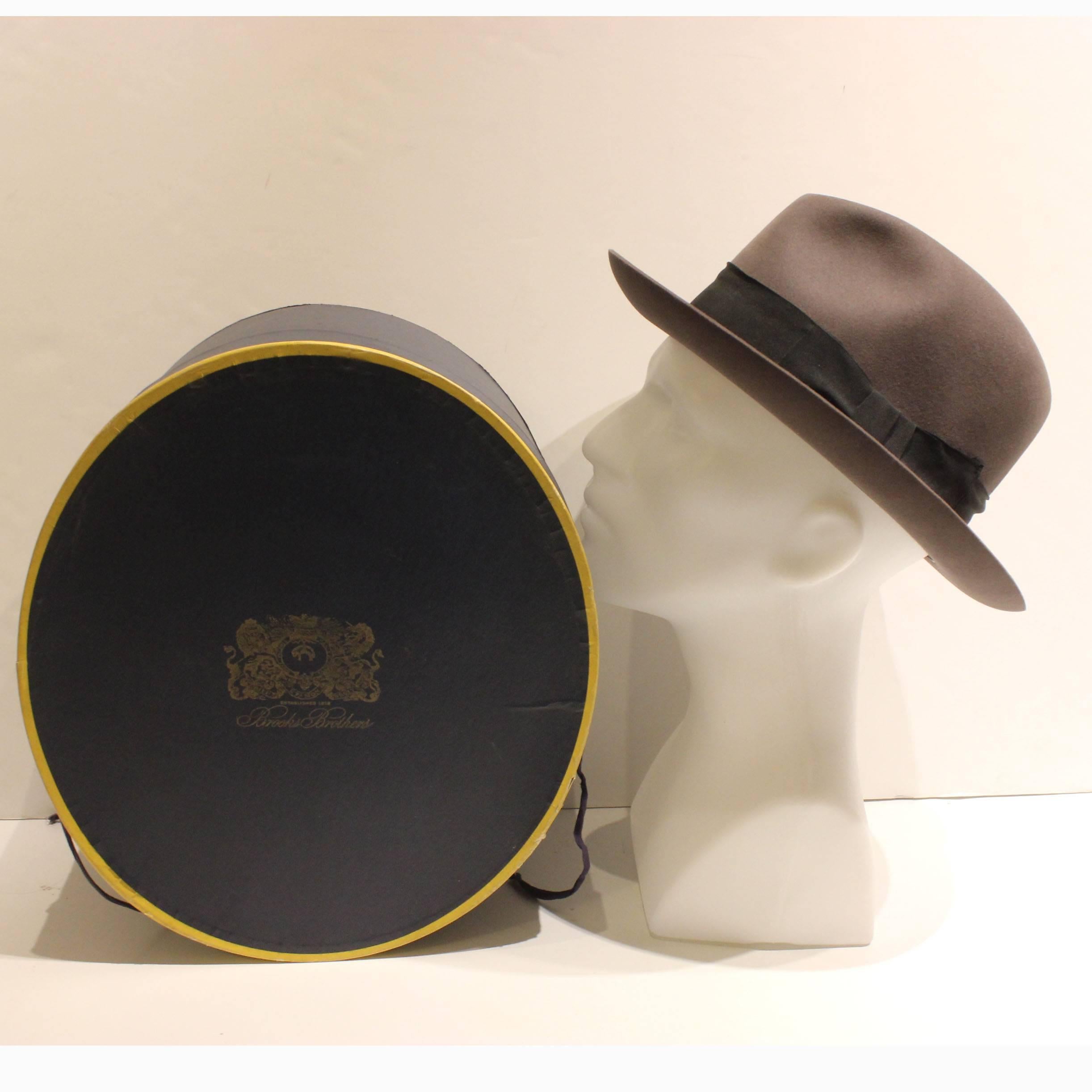 Classic, timeless Fedora. Gray with grosgrain black band. 7-1/4 hat size. This hat comes with its original blue and gold box from Brooks Brothers, which dates as pre-1963.  The hat box is in good condition, but the box top has experienced some wear