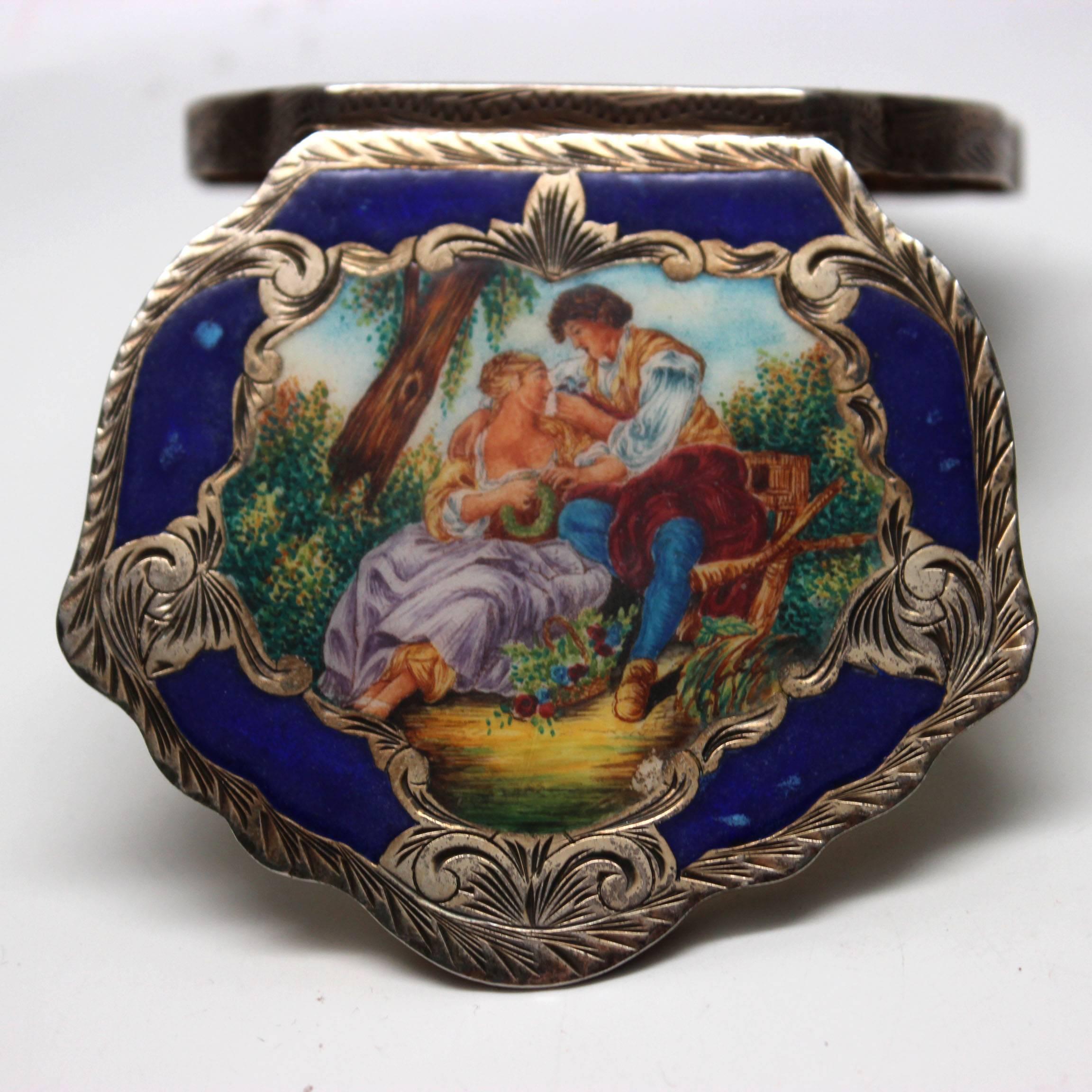This beautiful compact is made of stamped 800 sterling and hand painted enamel, with a faux lapis trim framing the image and detailed sterling. The colorful courting scene is Francois Boucher's 