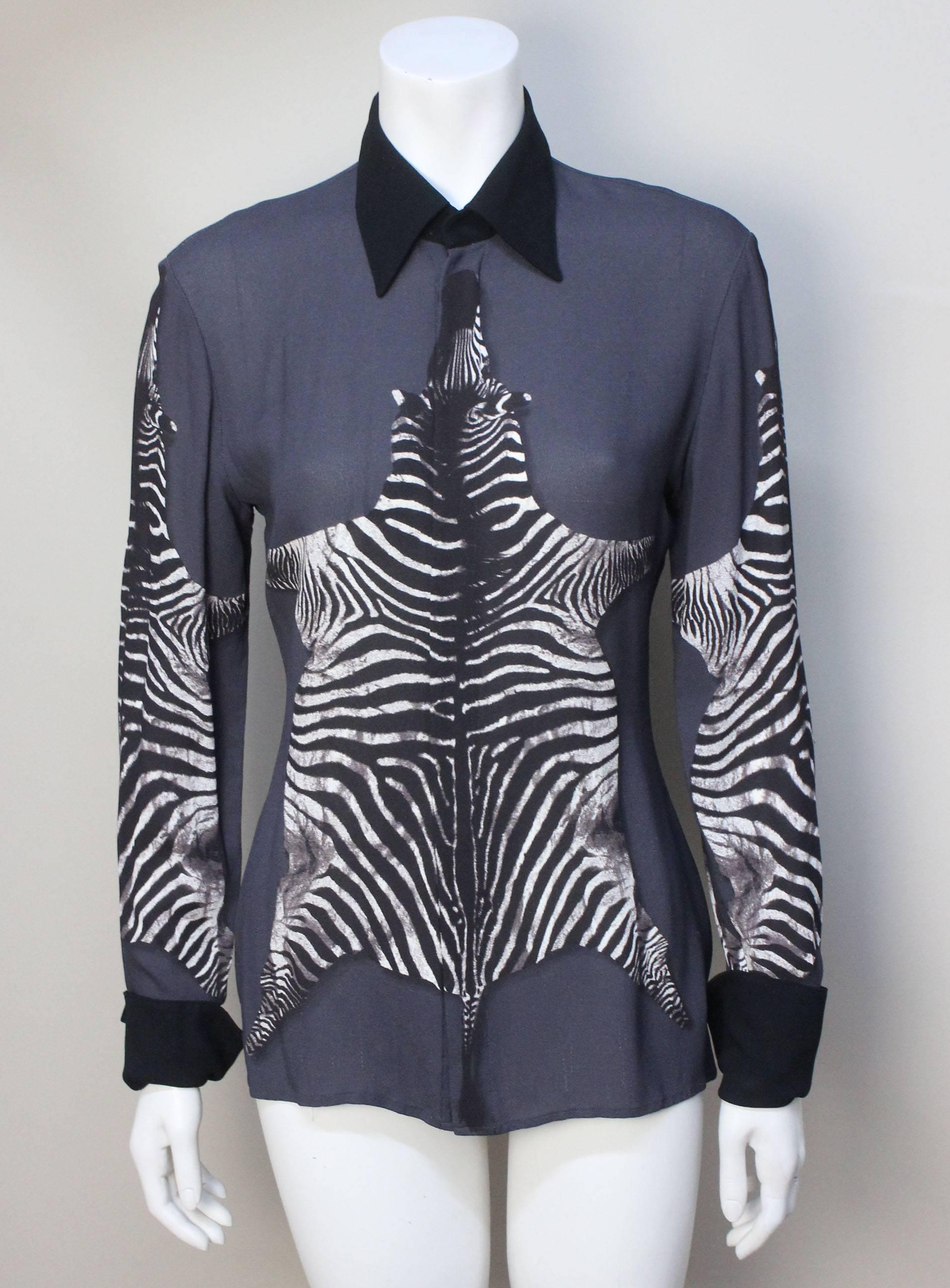 This sexy sheer blouse has a graphic of a zebra skin centered on the front and back as well as the sleeves. It has solid black crepe collar and cuffs that are a contrast to the sheerness of the top. 