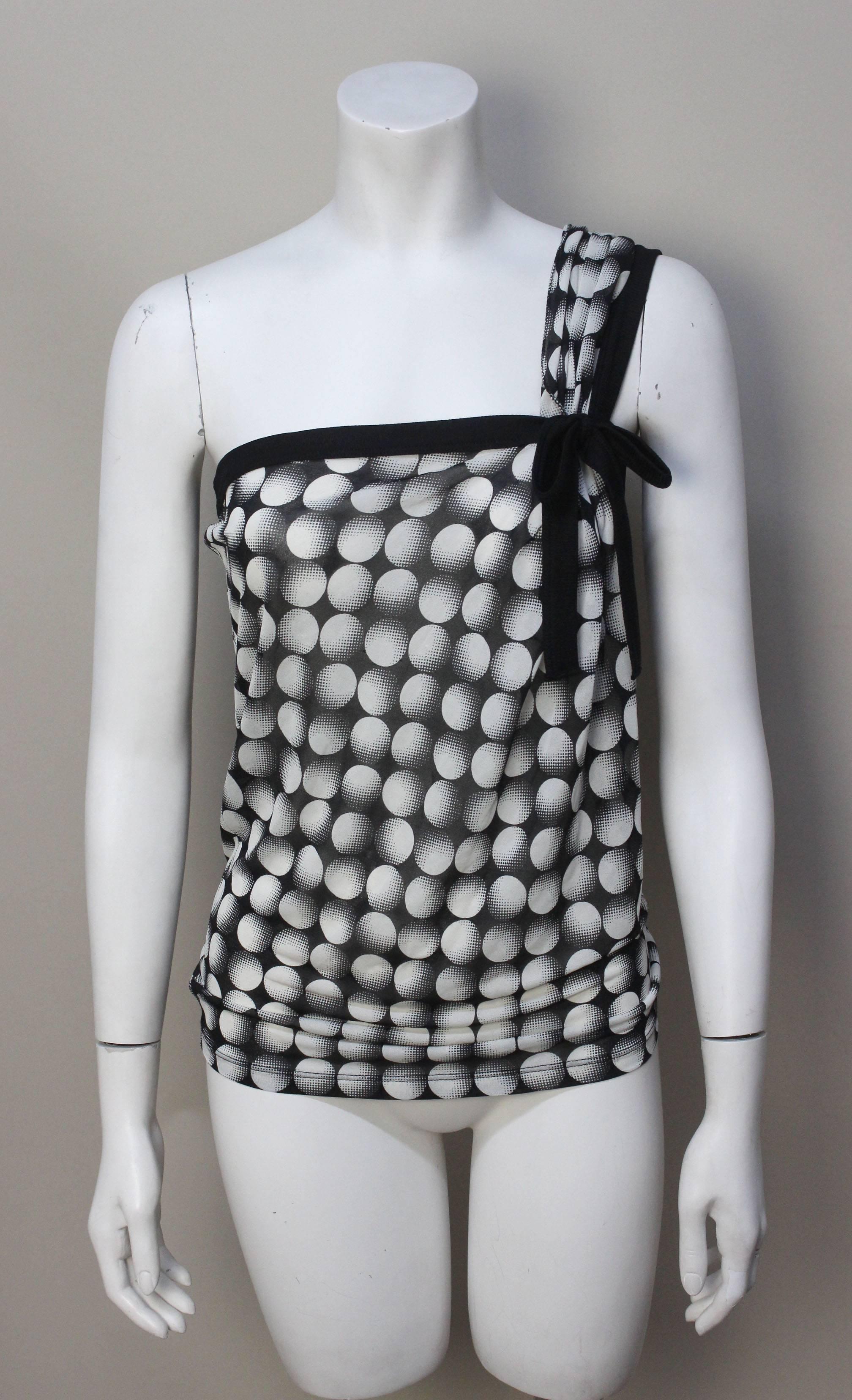 This sexy sheer top has lots of style. It drapes beautifully from one shoulder in soft gathers anchored with a bow. The pattern of graphic dots have an op art effect. 