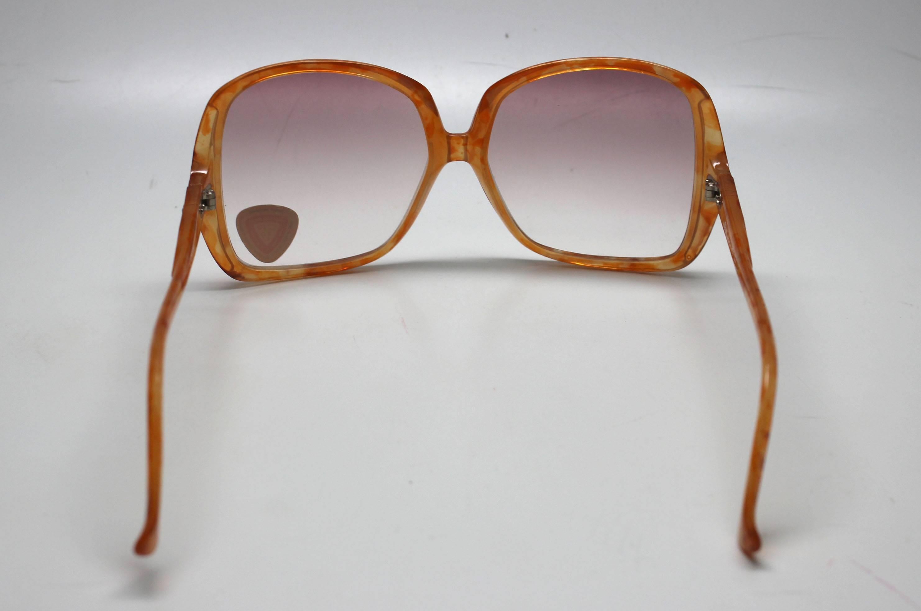 This pair of orange speckled shades comes from a collection of sunglasses that had been warehoused since the 1970's. They are good quality, the frames were made in Italy. The style is very au courant to today's trends. 