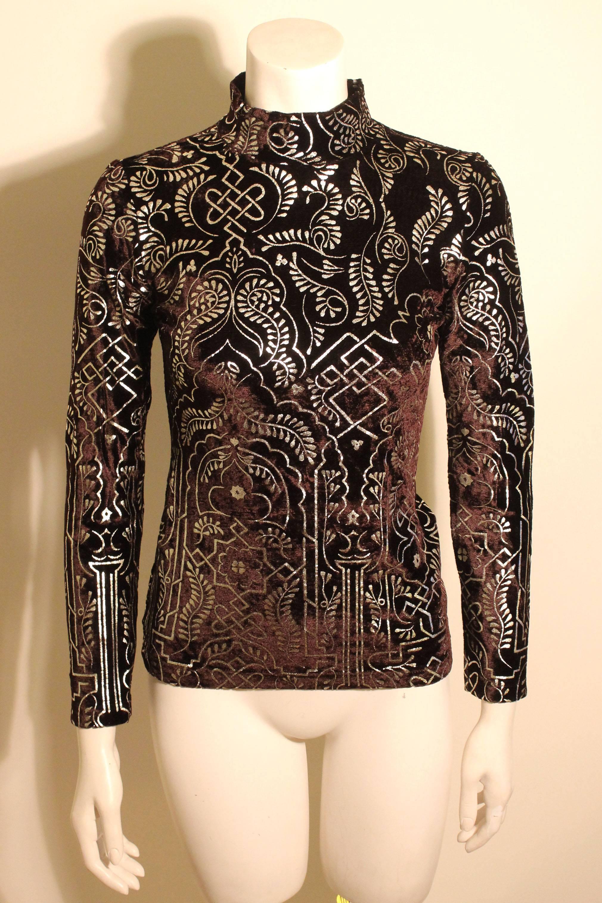 This velvet Joseph Tricot mock neck top is embellished with a silver embossed floral & celtic design. It is hip length, fitted to the body with long narrow sleeves. It is a perfect choice for holiday dressing. 