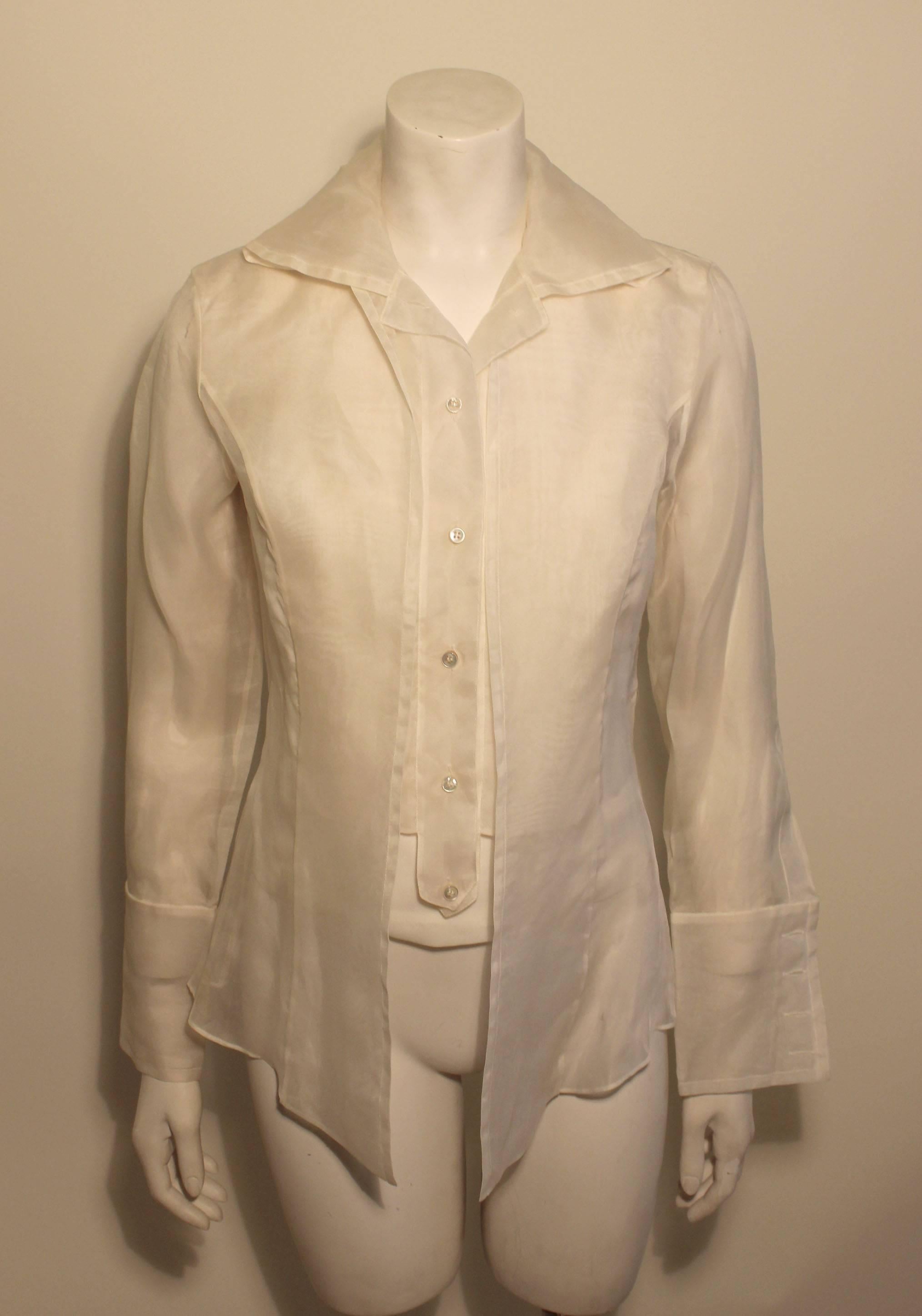 The lines of this 2 piece silk chiffon Gianfranco Ferre studio blouse are lovely. The front has a three layer effect with the camisole and a short vest like insert under a longer blouse with a peplum back. There is a generous cuff with 4 buttons at