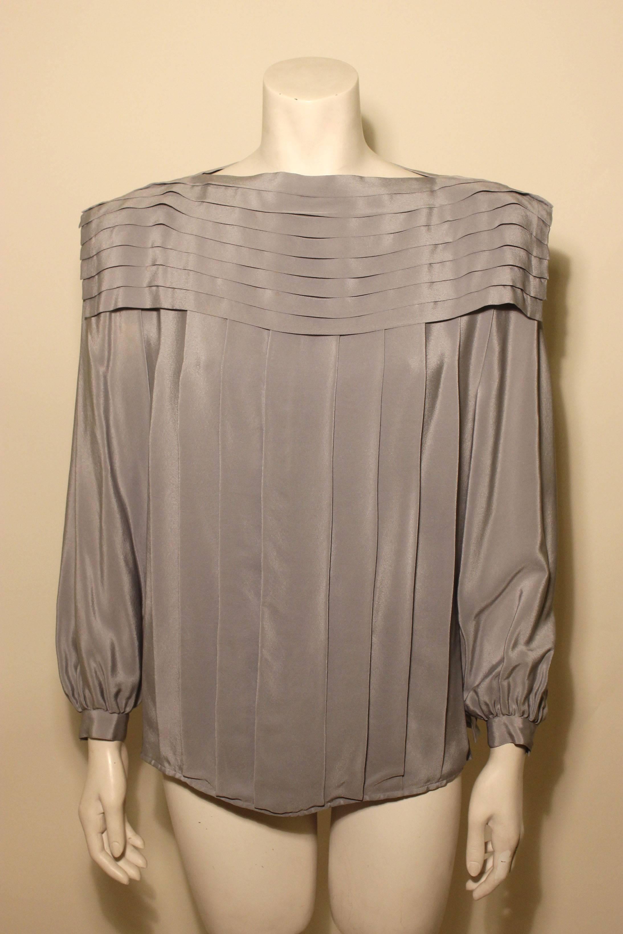 Basile is known for fine fabrics and tailoring. This piece has both elements. This dove grey blouse is made of a fine silk. It drapes beautifully with a yoke of horizontal pleats and a body of vertical ones. 
