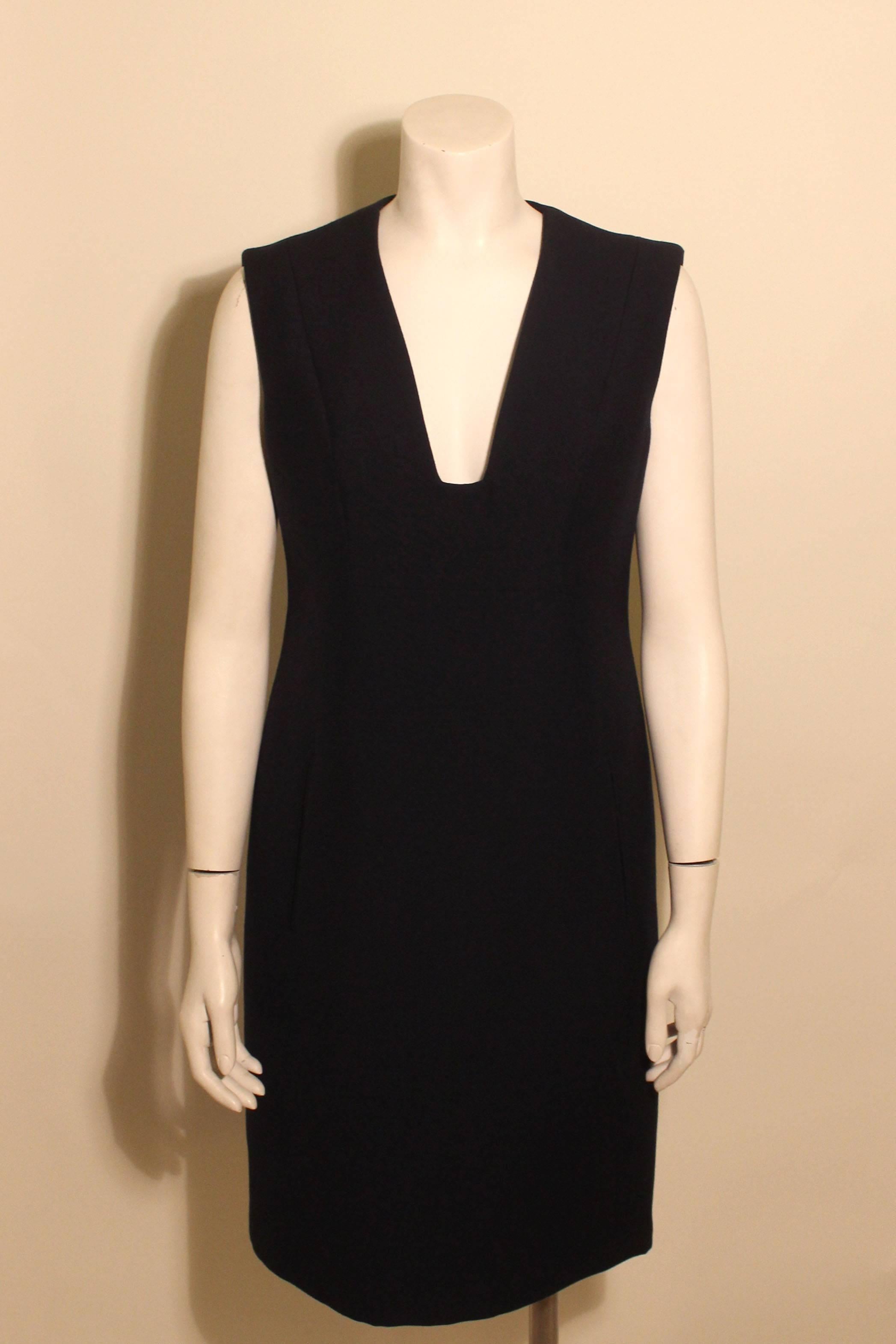 This navy Trigere dress is a classic timeless design. It has a deep v neckline and two front pockets. This chic dress is made of a fine wool and is completely lined. 