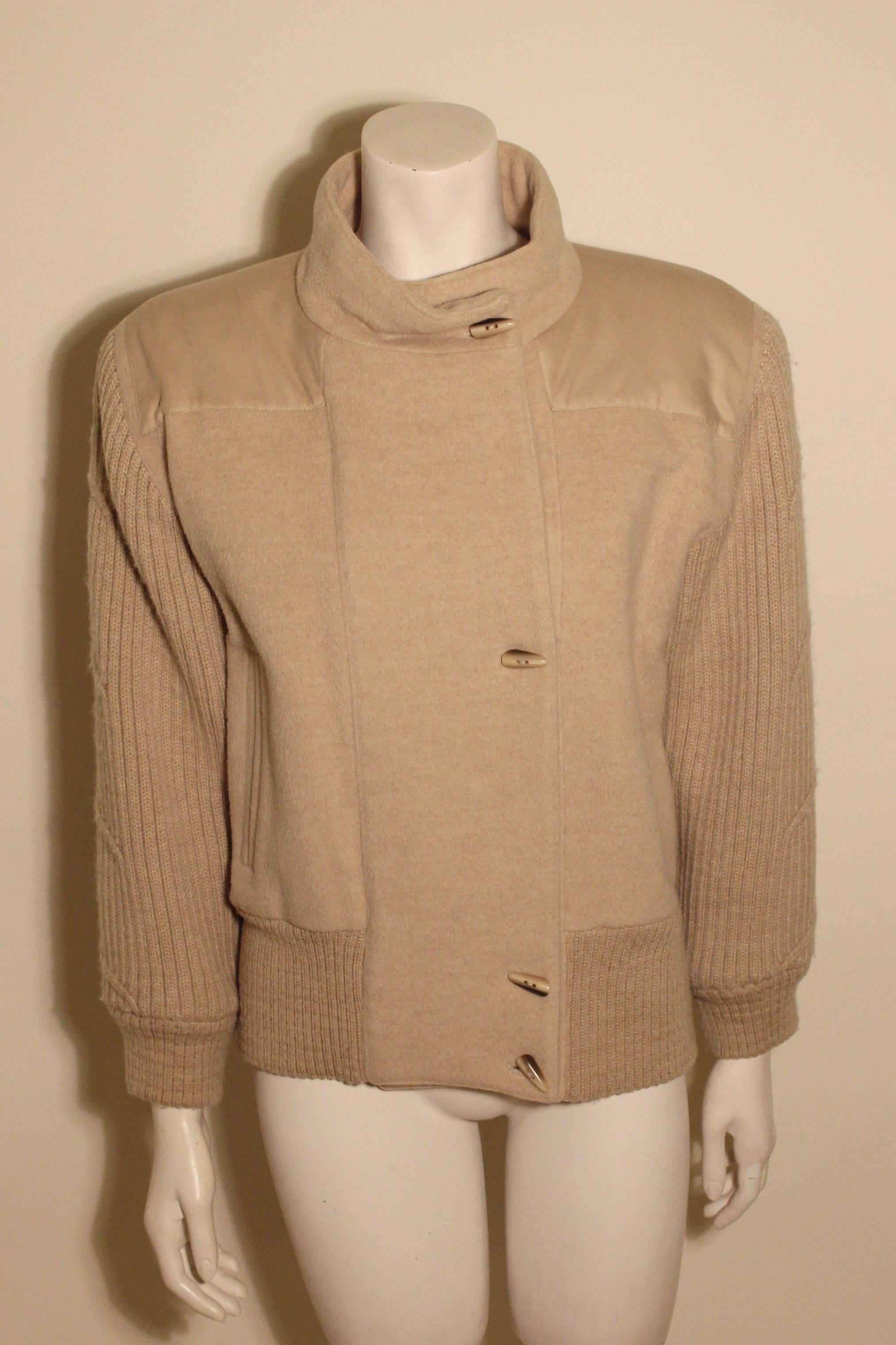 This camel hair Claude Montana jacket is strong on style. It has nice details with a high neck, a cotton yoke, and heavy ribbed sleeved and waist. It has toggles to close the front and two slash pockets. 