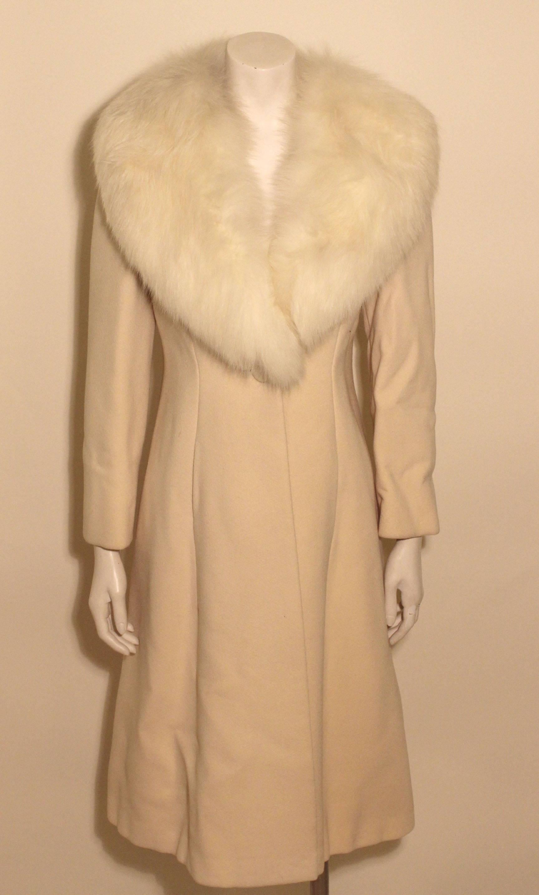 This luxurous Pauline Trigere coat is the epitome of style. The creme colored long coat has a classic single covered button, and a full white fox collar. 