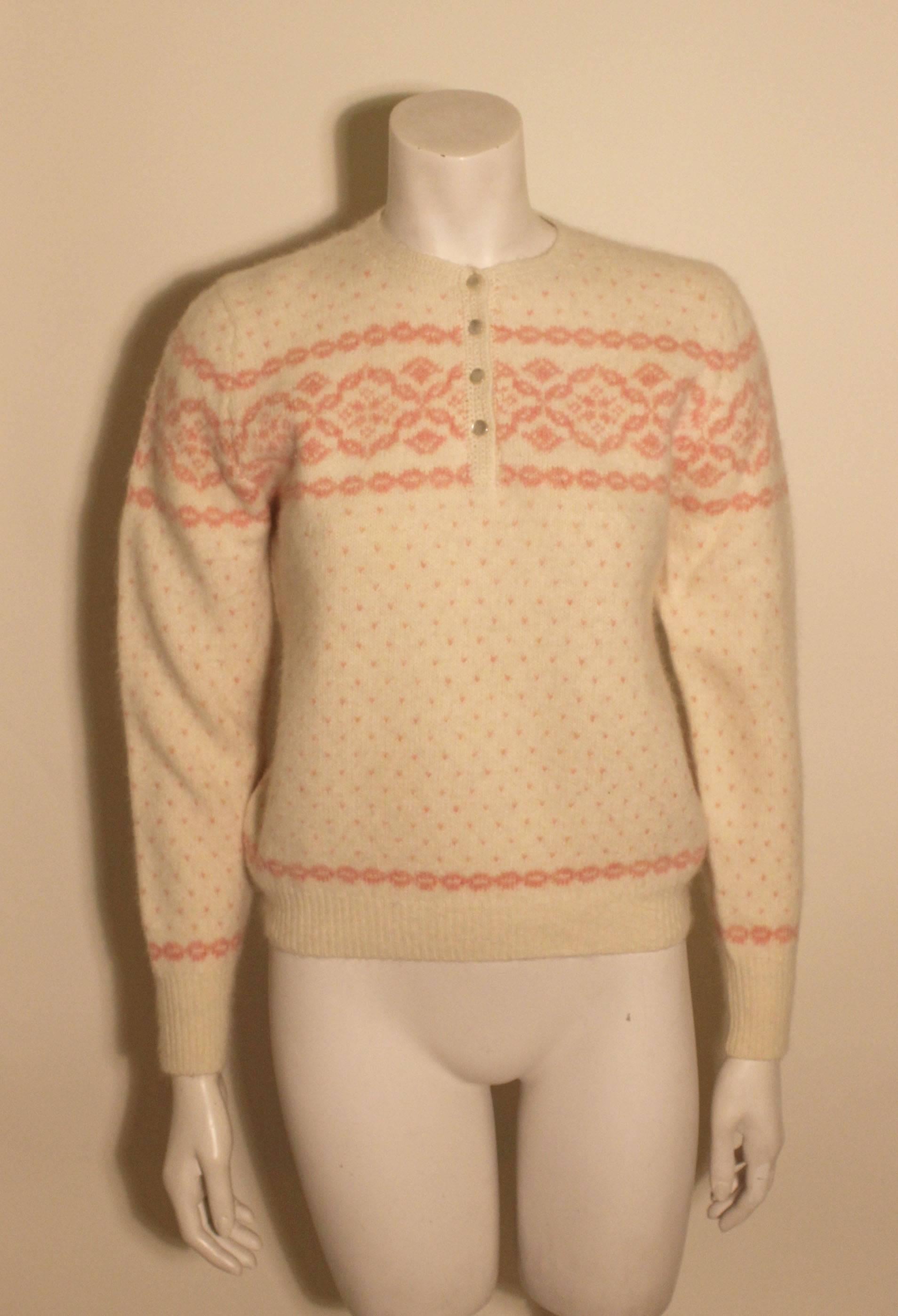 This Fair Isle sweater is from Deans of Scotland, known for their fine knits. The cut is classic with four buttons at the front with a lovely pink design on the light creme colored wool.