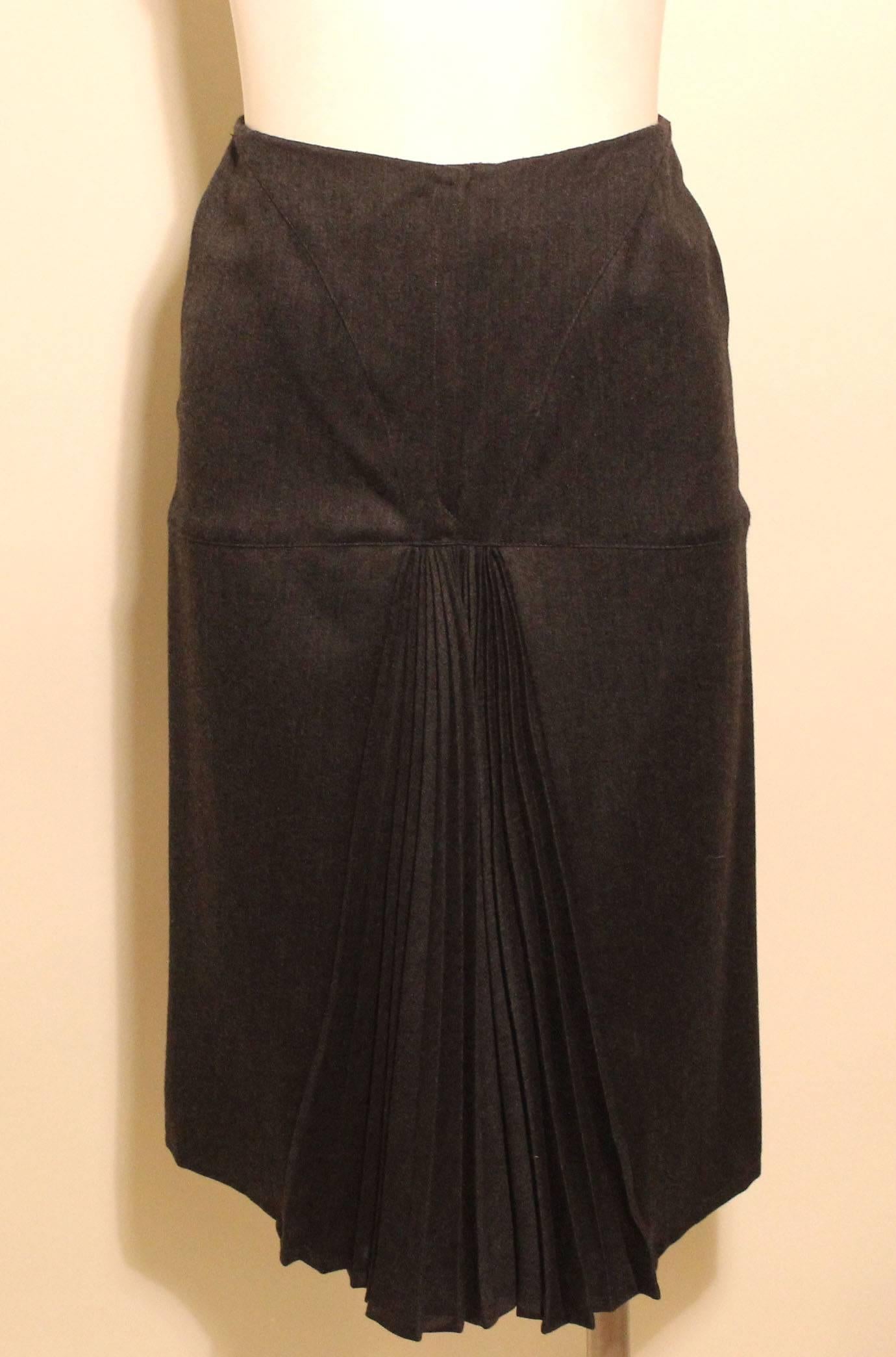 This grey fine wool Claude Montana skirt hugs the curves of the body with the addition of flirty front kick pleats.