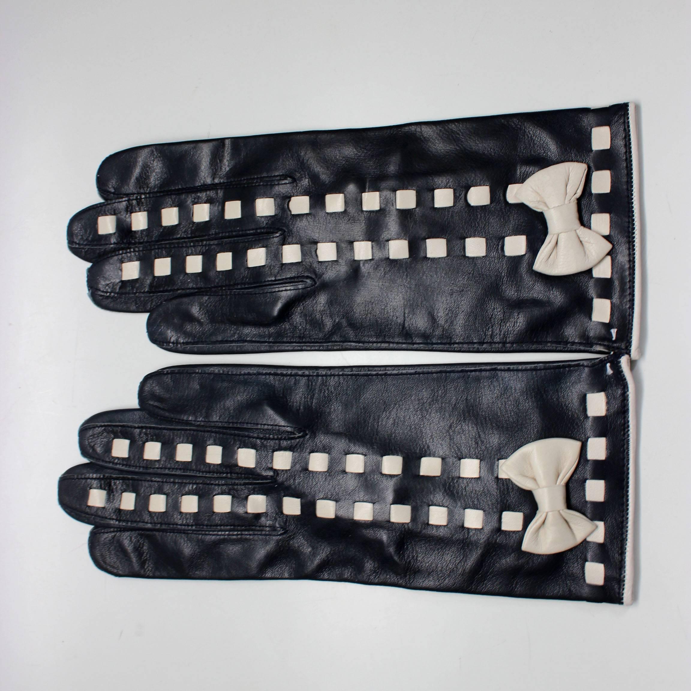 These chic 1980s Escada gloves are a great find. The midnight blue leather is brought out by the details of the white bow and woven rows on the front. Marked as size 7, made in Germany. Never worn, original Escada tags attached. 
