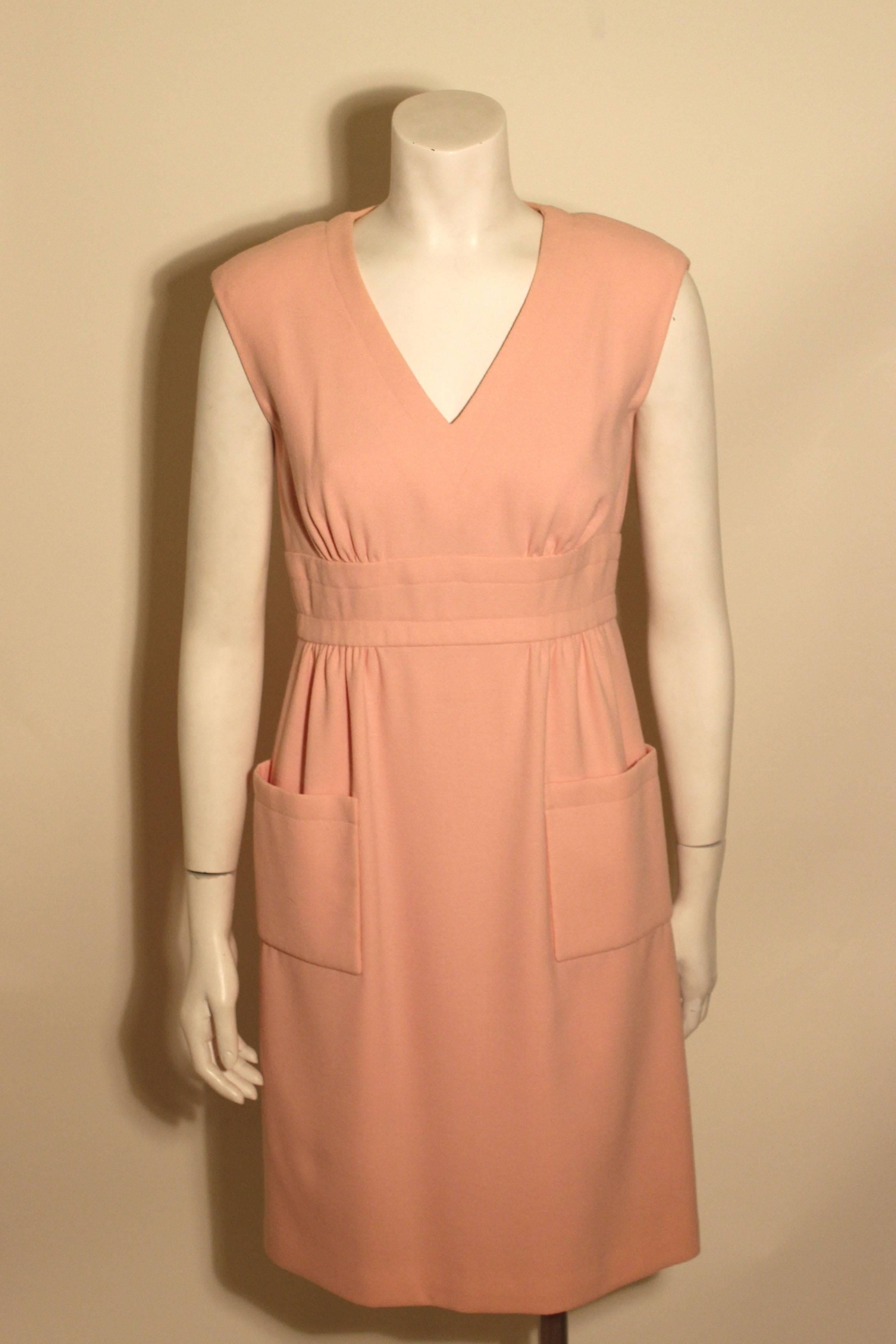 Vintage 1960's style baby pink dress by Trigere featuring a flattering V neckline, a defined waist line with delicate gathers, and two patch pockets at the hips. It has a full silk lining. 