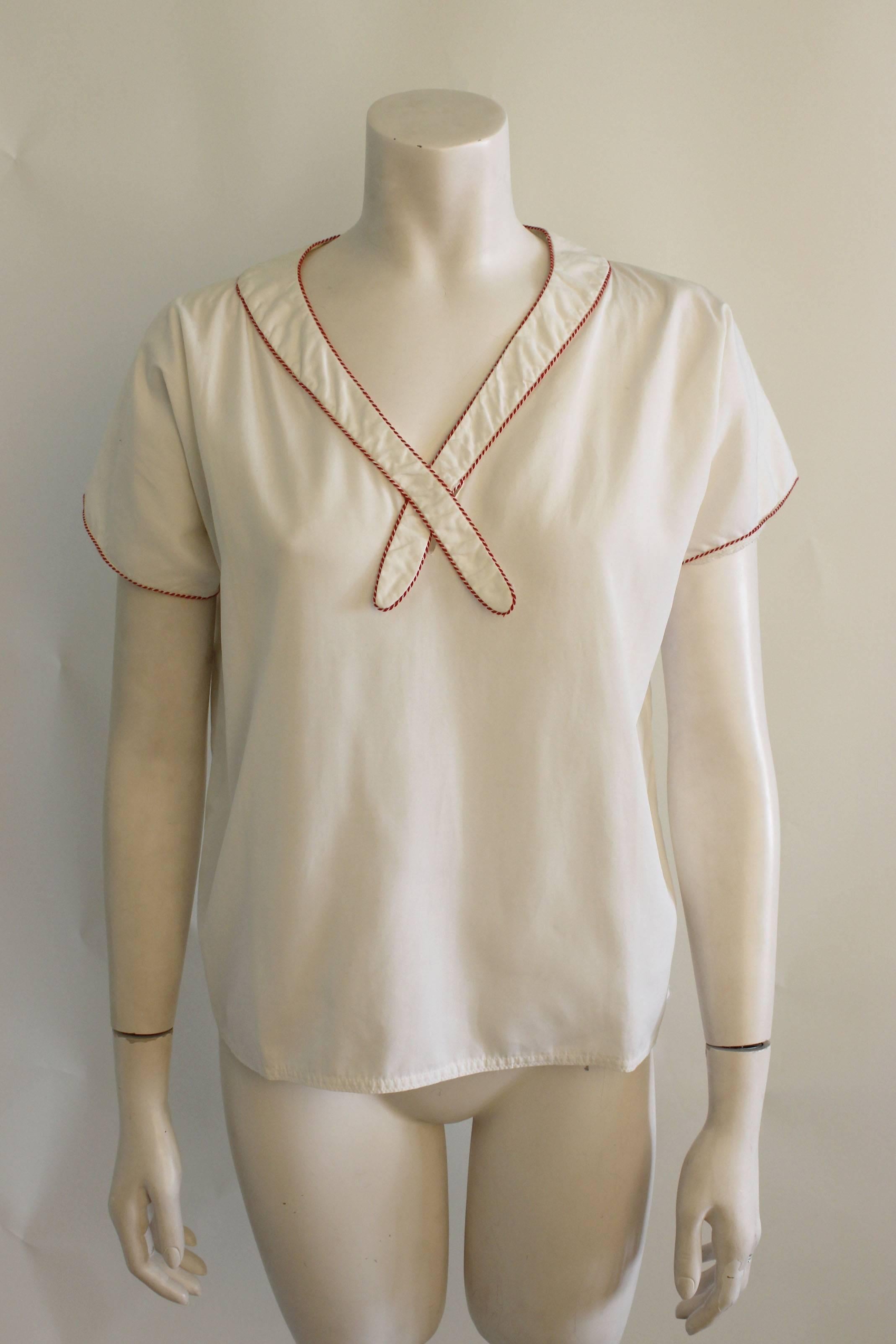  This sweet blouse by Geoffry Beene is a simple box shape in white with red and white piping.The label reads Beene Bag 