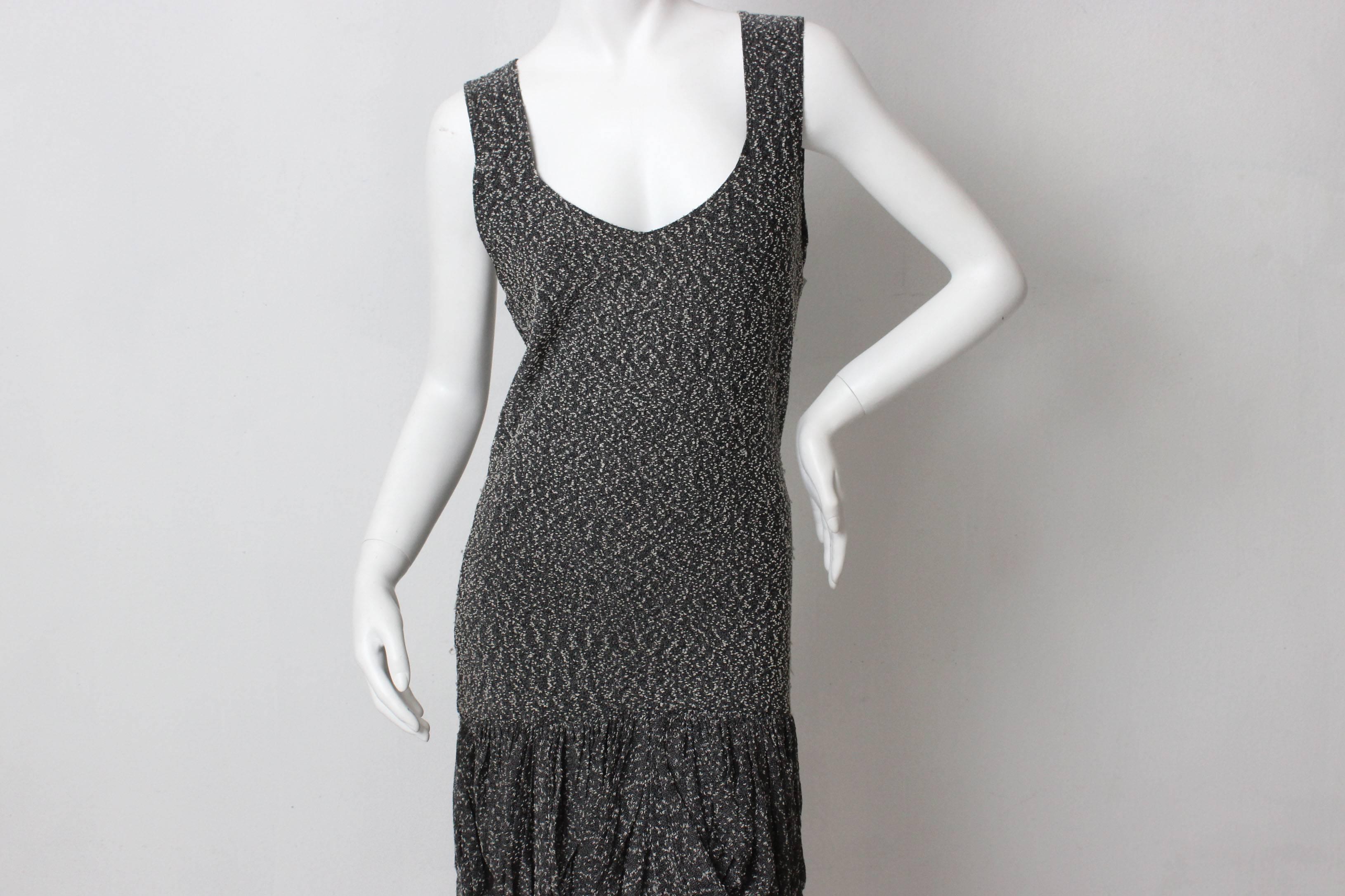  This dress is a departure from the well known Missoni knit patterns. The body hugging shape is made a sophisticated grey and black boucle. It has a low neckline and is fitted past the hips.  The fabric is gathered into beautiful draping  at the