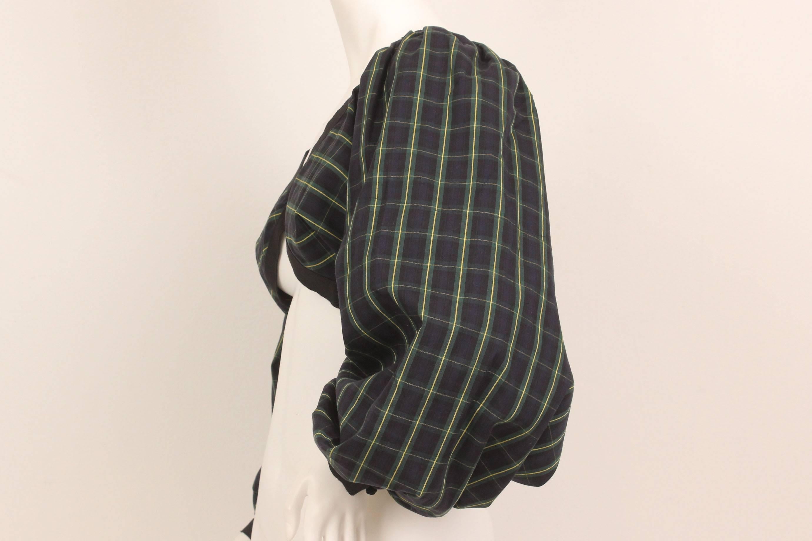 Truly a piece of design ingenuity, this crop top is all about its fabulous sleeves. Fastens with a hook at the center back and snaps at both wrists. The plaid is a navy with green and yellow stripe and black grosgrain ribbon trim. Would be stunning