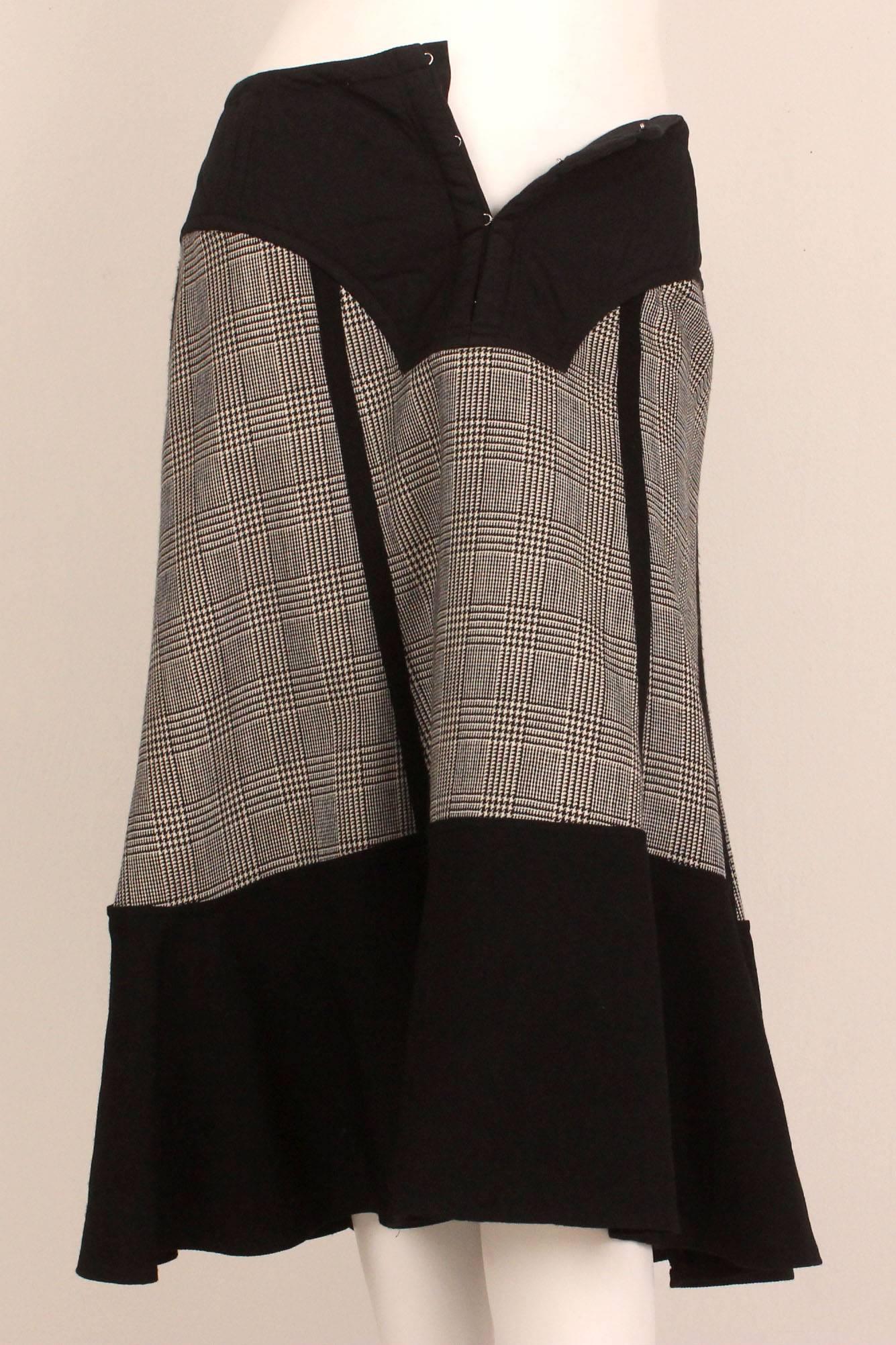 This Comme des Garcons A line skirt has wonderful details. The skirt is made up of three fabrics.  The form fitting elongated waistband is quilted cotton and attached to it is a fine herringbone wool. The last fabric forms a wide hem and is in a