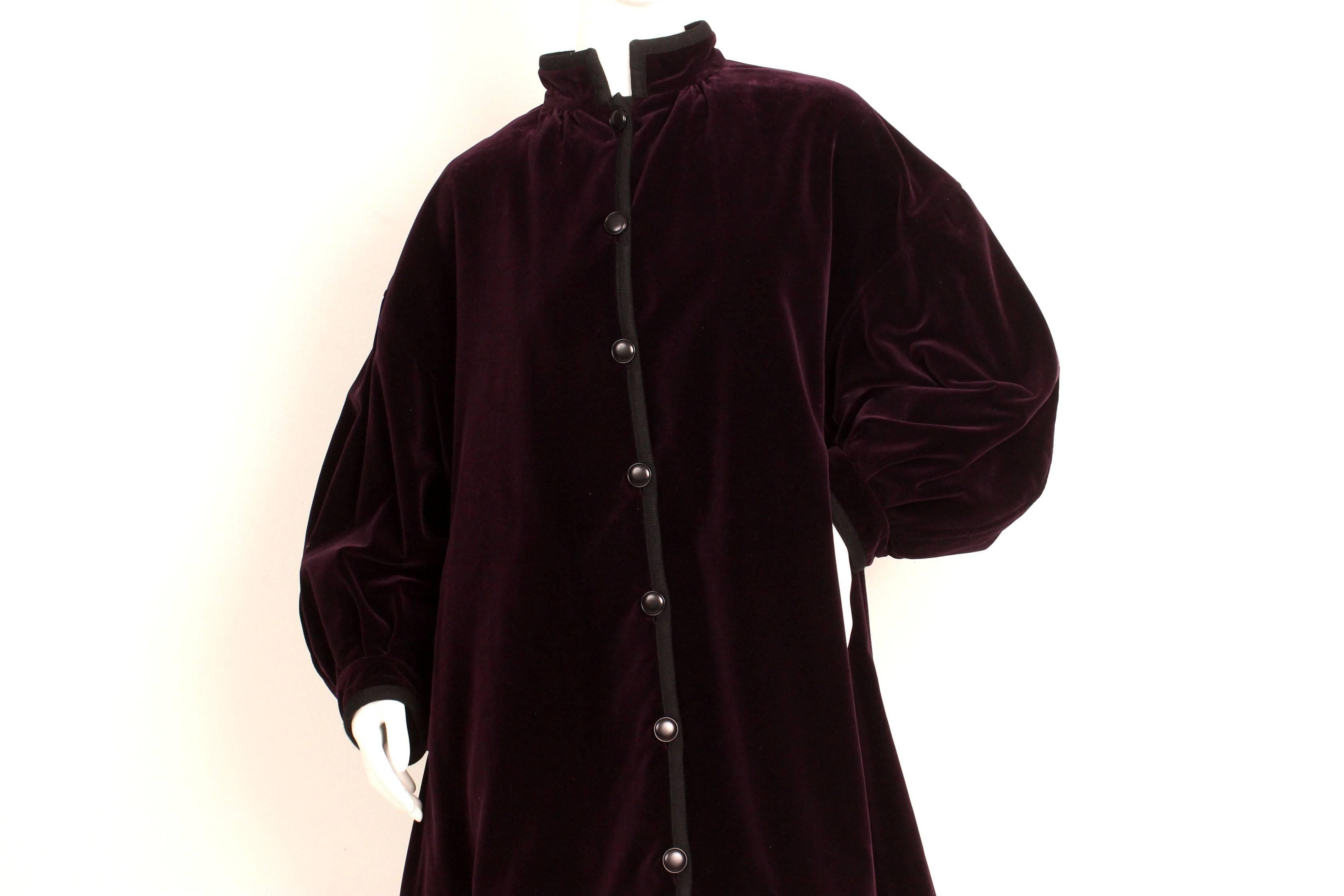This jacket is a standout piece from Yves Saint Laurent's Rive Gauche 1977 collection.   The fabric is a lush velvet in a jewel tone deep purple.  The shape is trapeze like with beautiful wide exaggerated set in sleeves. Black buttons adorns the