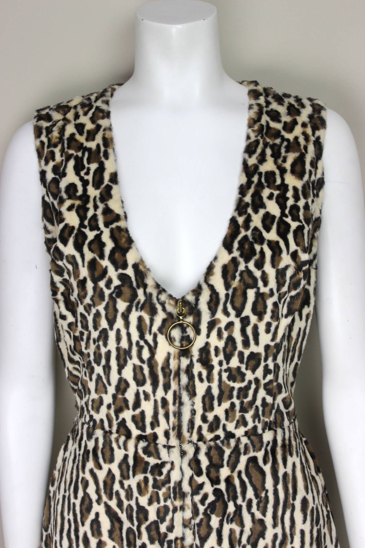 This jumpsuit has quintessential 1970s design elements: an elongated
zipper front with a large ring pull, a super wide bell bottom and a
faux fur leopard print. This sexy 1970s look is perfect!