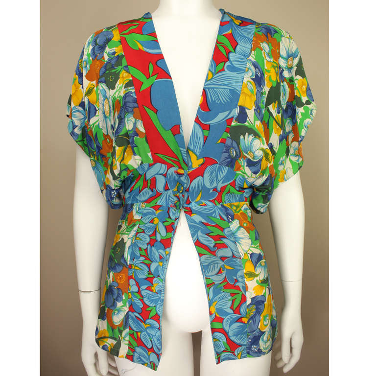 This blouse tunic harks back to Carnaby Street at its finest hour in fashion. It evokes the style of Ossie Clark and other fashion renegades of that period. This beautiful top is a patchwork of two vibrant 60s florals. One on the sleeves and hip and