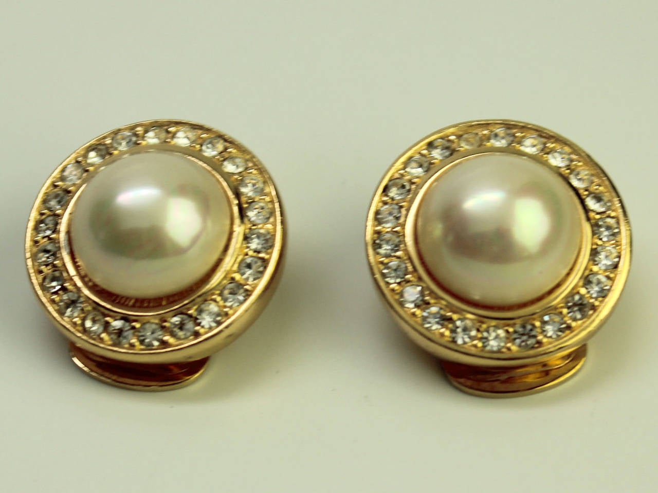 These Christian Dior 1980's gold plated rhinestone and pearl earrings are a classic addition to any wardrobe. The style is similar to Dior's designs of the 1950's. The clip backing fits securely but comfortably on the earlobe.