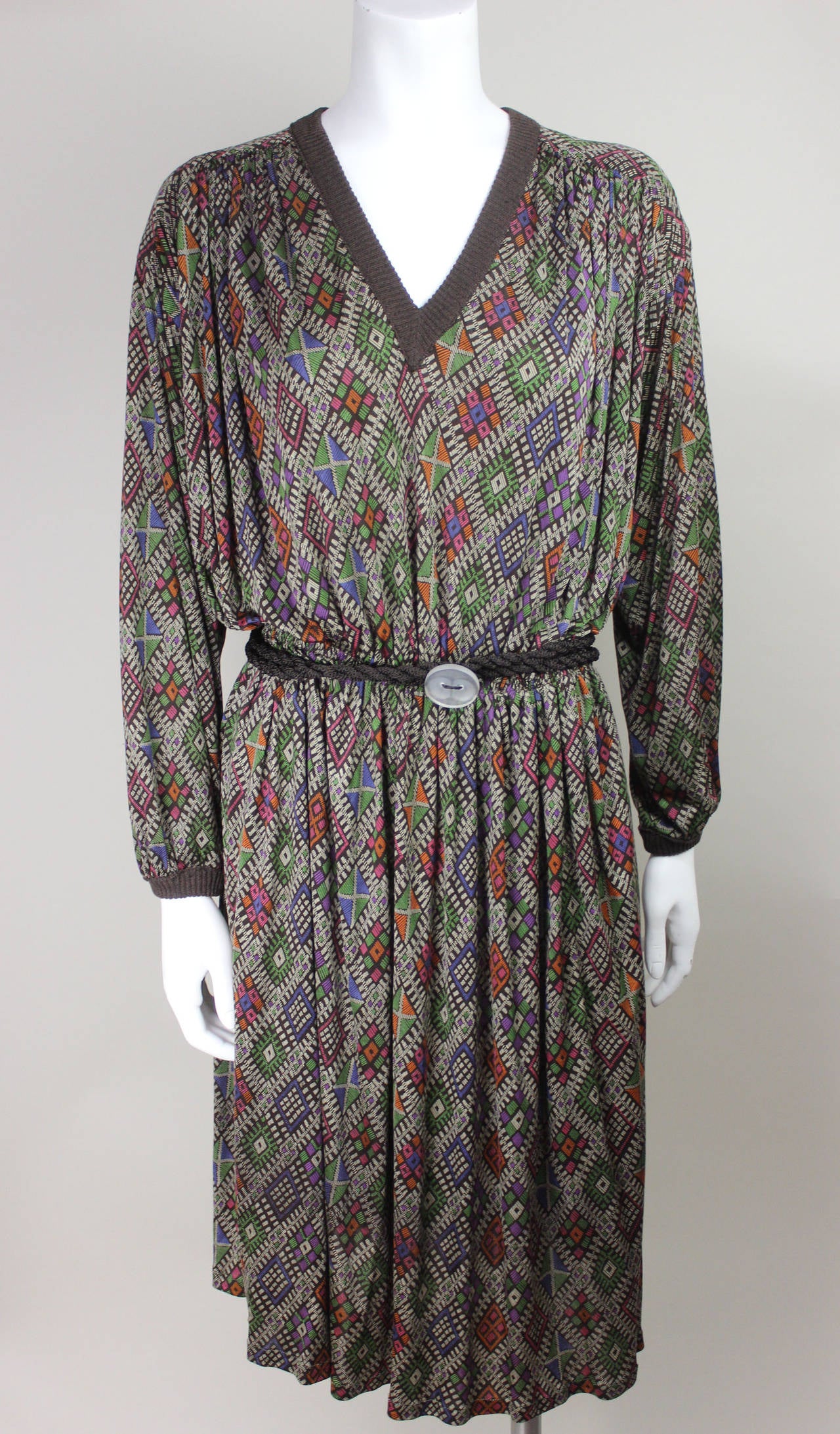 This is a rare Missoni from the 1970's with an abstract green, brown, and orange pattern. It has a deep V neck and is cinched at the waist with the original rope belt. It is a slinky, subtly sexy silhouette. This is the exact design that we are