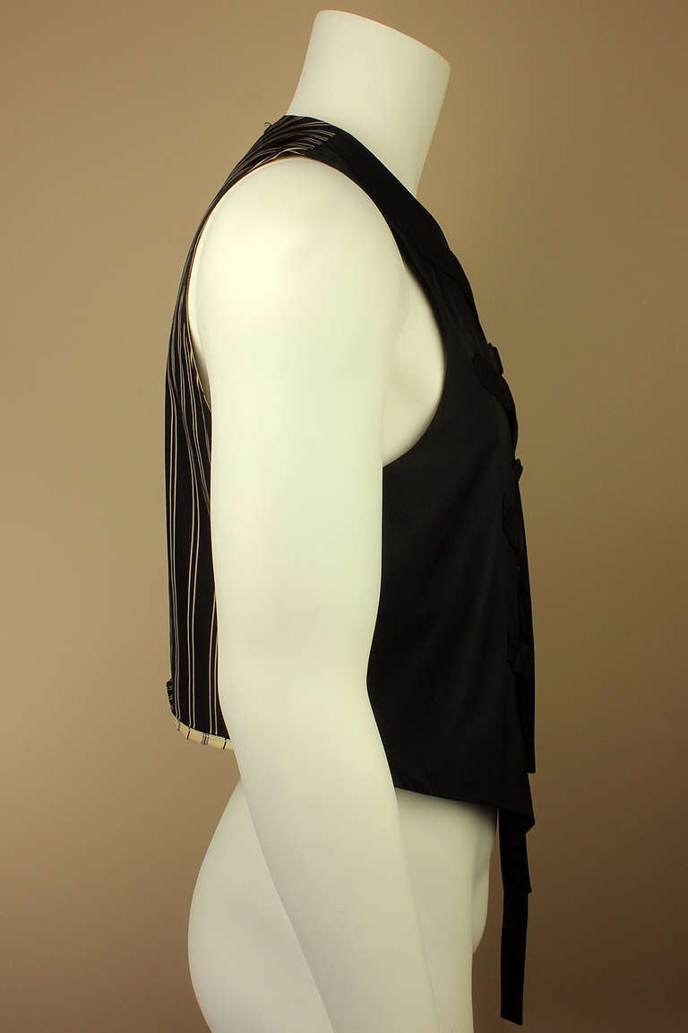 A classic men's silk vest with very unclassic and pure Gaultier, asymmetrical, bondage straps as front closures. The back and lining are of contrasting silk stripes.