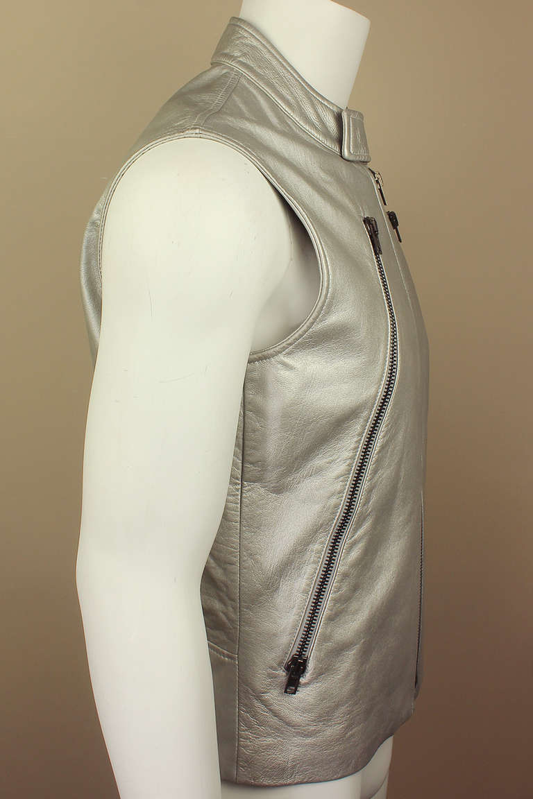 This Margiela vest has it all. Moto style with two long diagonal zippers down the front and a high snapped neck in a supple leather that has been painted silver. It is tagged 