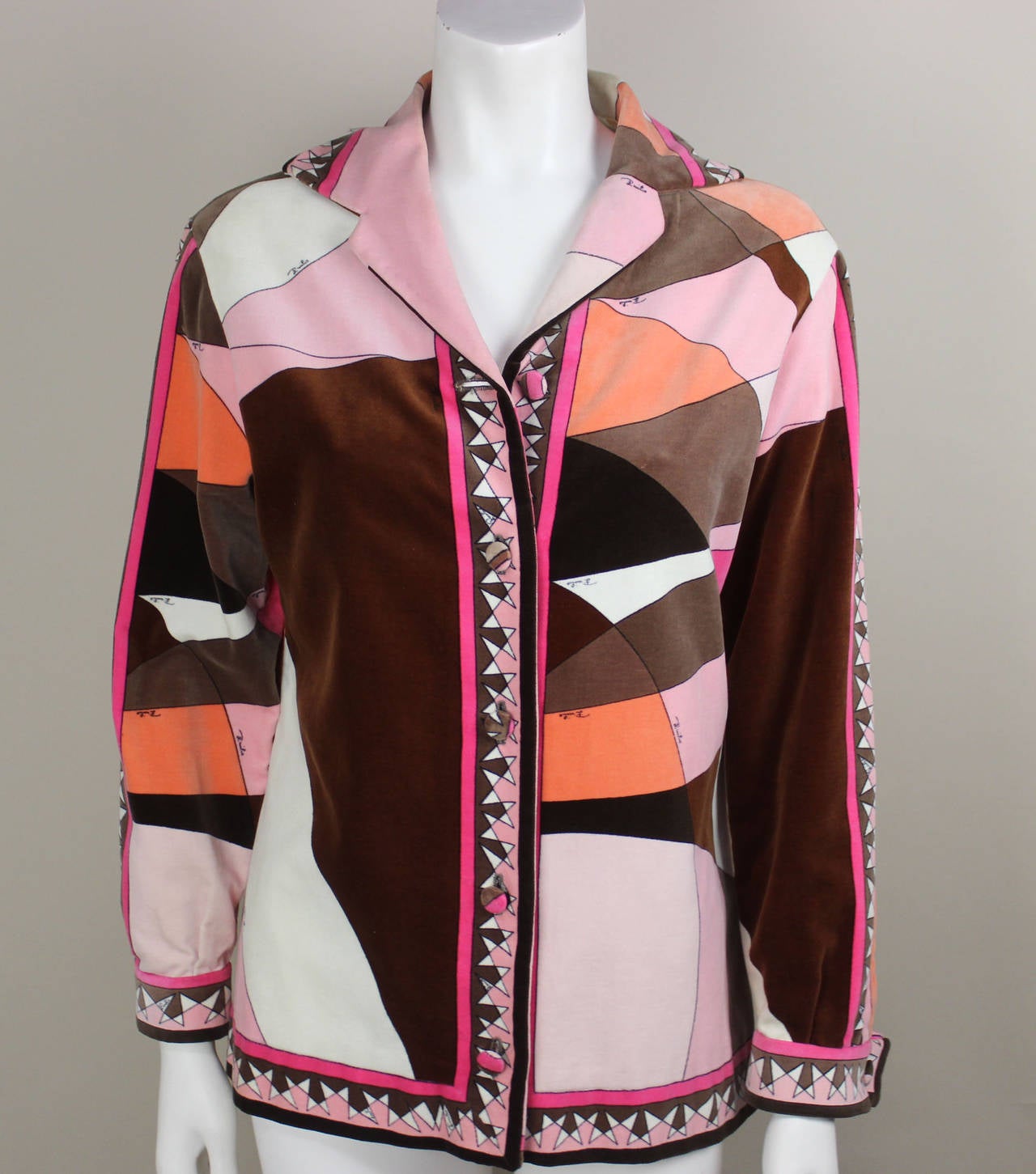 This vibrant Emilio Pucci cotton velvet has an iconic late 1960's geometric design with the Pucci signature throughout. It has a notched collar and buttons down the front and at the wrist with velvet covered Pucci buttons. The jacket is marked as a