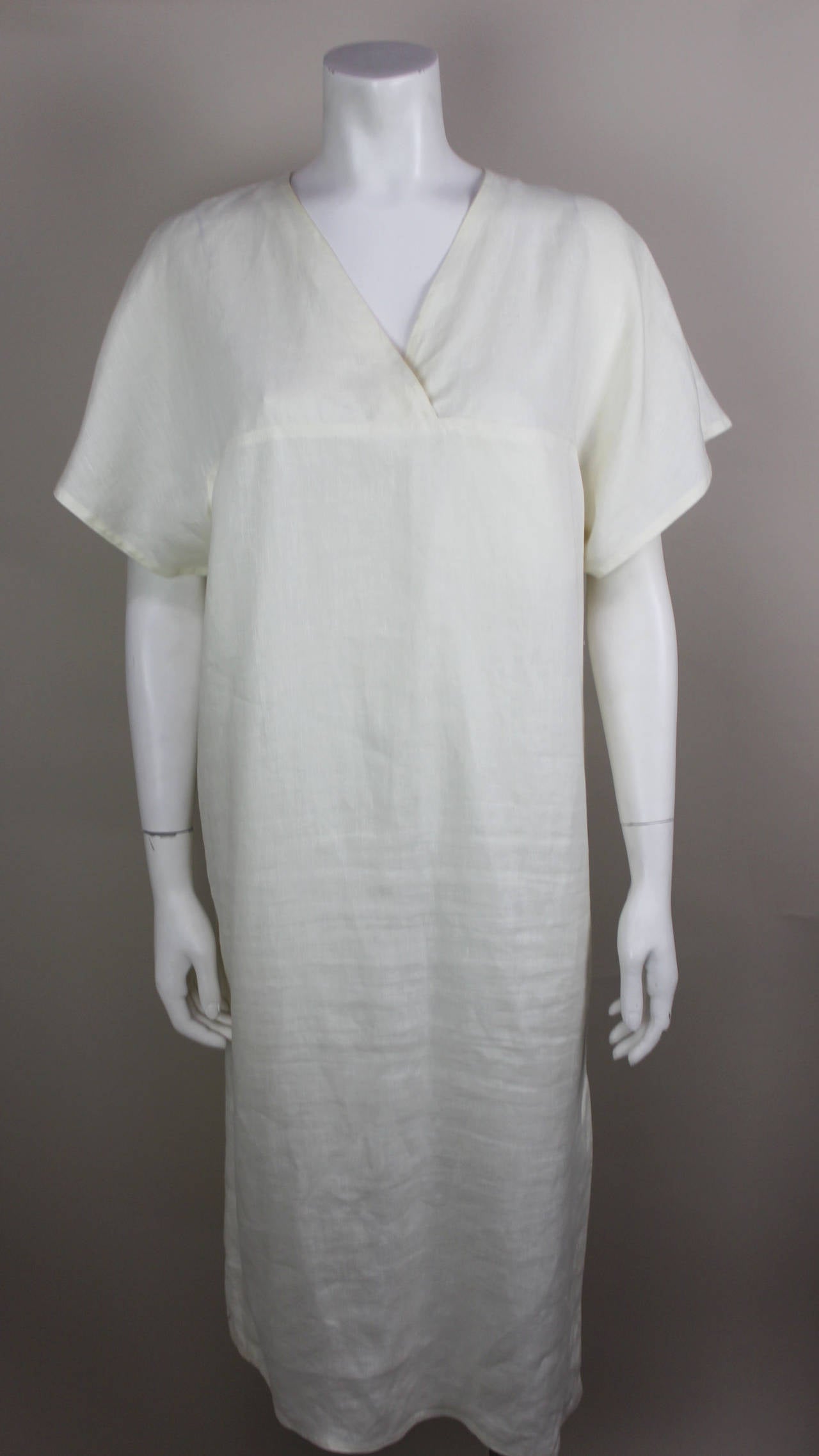 This creme linen dress is beautiful in its simplicity. It has no adornment other than three mother of pearl buttons at the bottom on the side seam. The sleeves are in a short kimono style. It's the perfect summer dress!