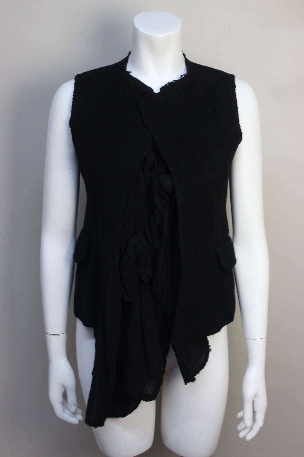 As with all Comme des Garcons designs, this top is ingenious. The outer shell is a heavy fleece unfinished vest, with pockets. It is attached to a black, soft cotton gauze layered and knotted in the front. It makes for a clever and wearable piece.