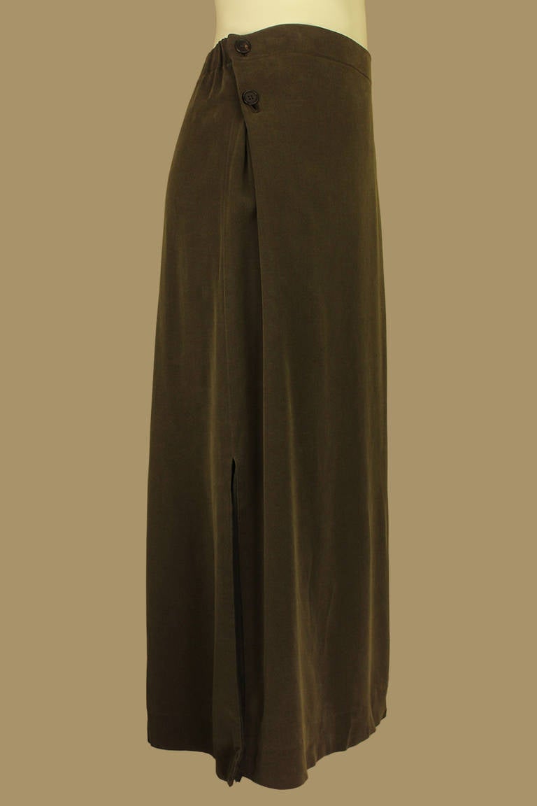 This Issey Miyake olive green skirt is simple yet elegant. There are buttons  on each side of the hip which allow it to be worn as either high- or low waisted. This versatile skirt also has two below-the-knee  side slits.