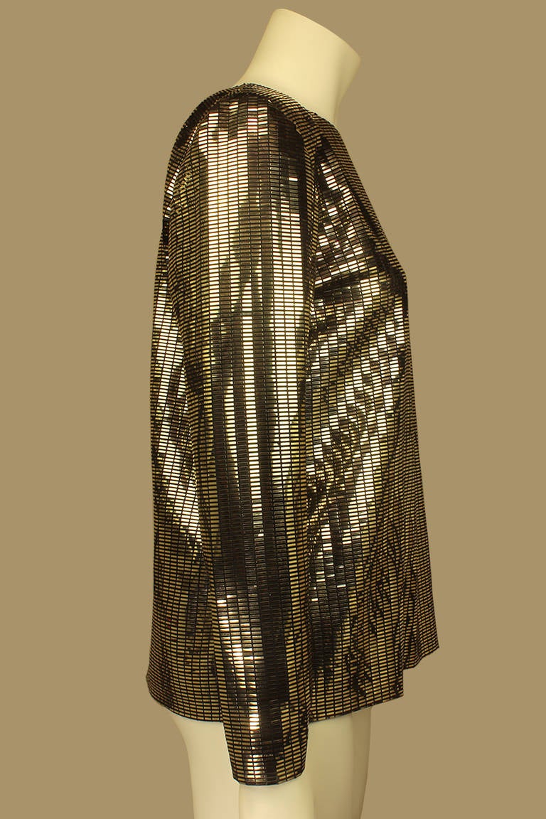 This is a most unusual 1960s top. It is covered in metallic, almost reflective rectangles on a sheer background. It is a chic '60s style but very relevant to today's fashion. The sleeves are slim with zippers. The top absolutely shimmers in the