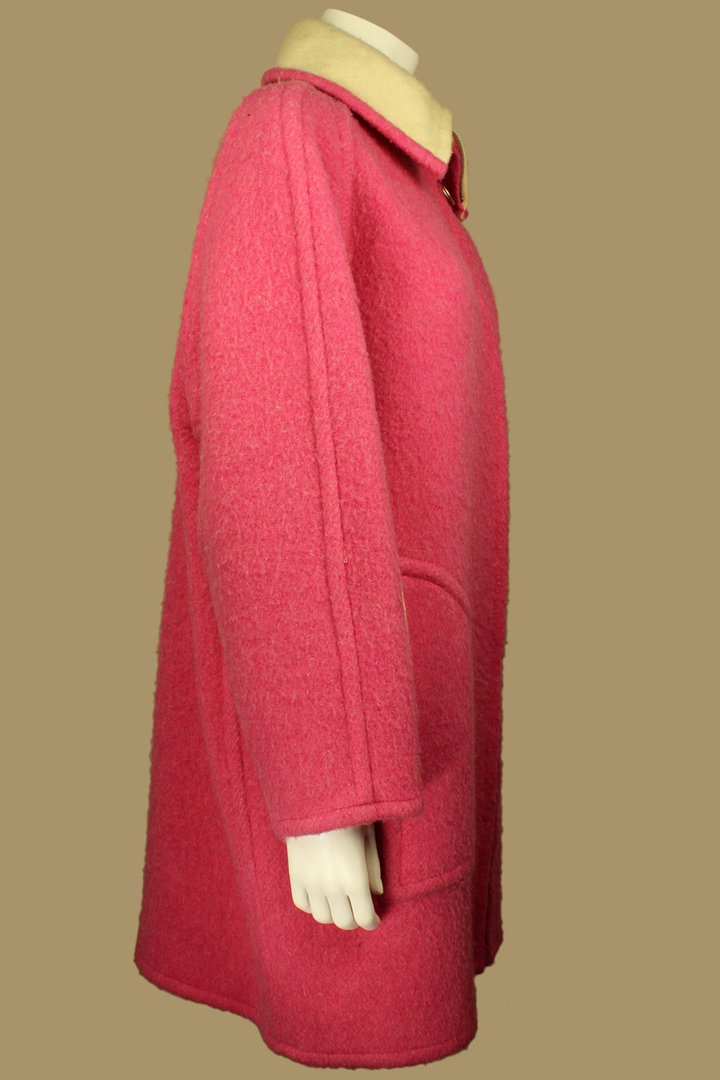 SALE! Originally $825
This is a fantastic Courreges piece. This cosy wool coat is in a vibrant rosy pink with a creme lining. It has a zipper with a ring pull running from the neck to the hem. It can be zipped all the way up creating a funnel-like