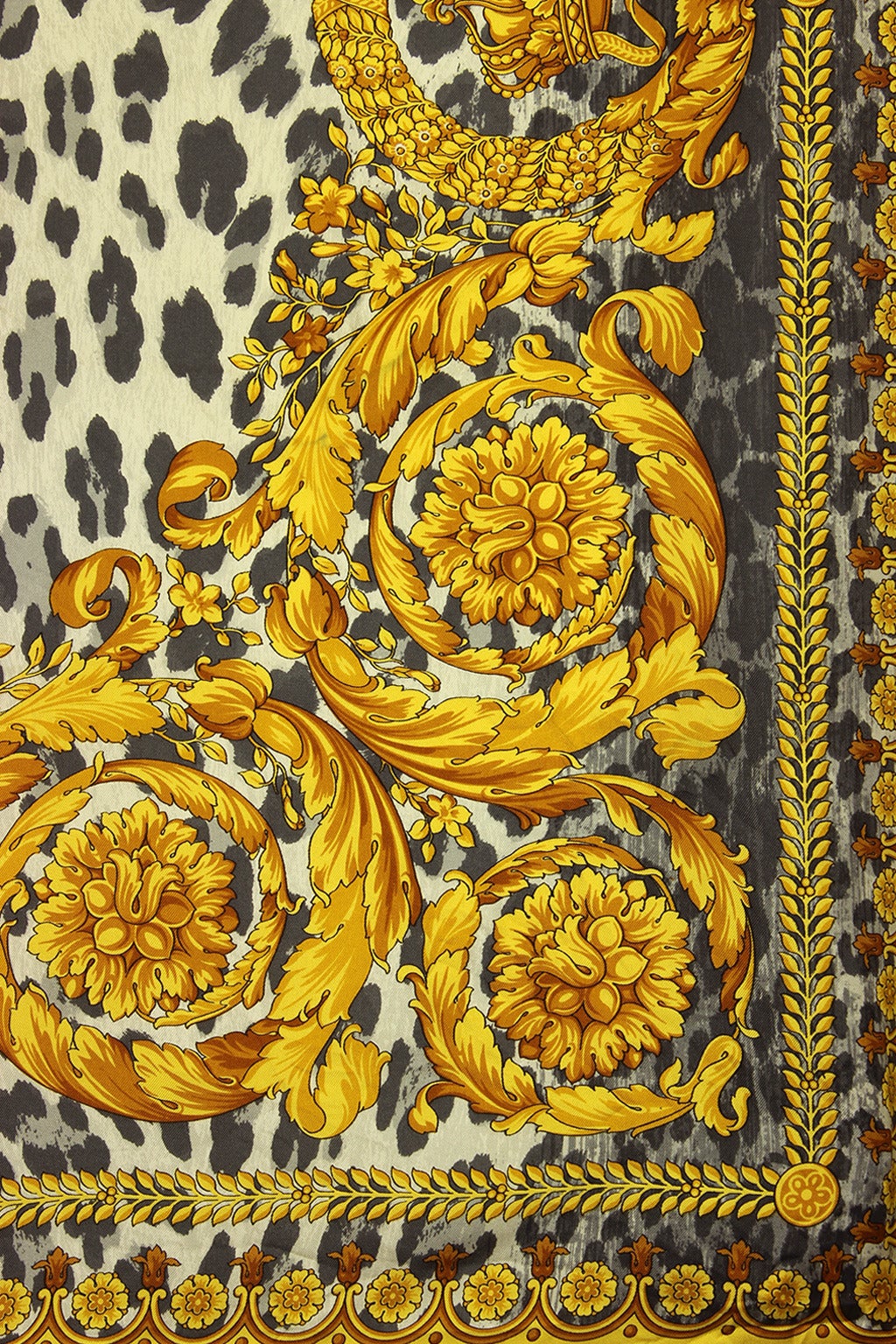 This is a classic Versace print with a leopard patterned background and gold Baroque designs along the border. This Versace signature print scarf makes a great gift.