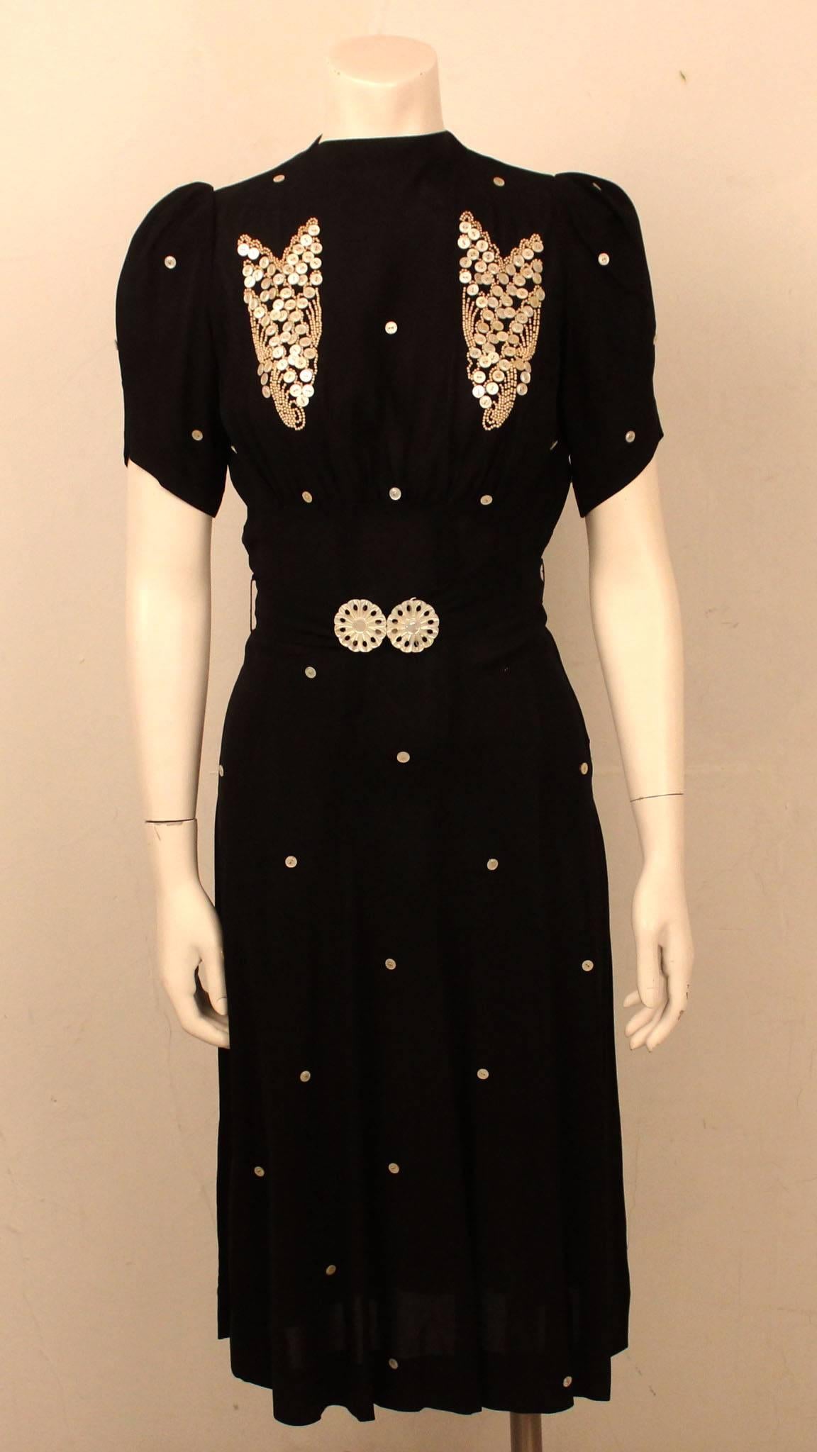 A silhouette straight out of Hollywood's Golden Age, it is easy to imagine Ava Gardner or Bette Davis in this very dress. Mother of pearl buttons dot the dress and comprise the two heart patterns over the chest. An adorable waist belt, also with a