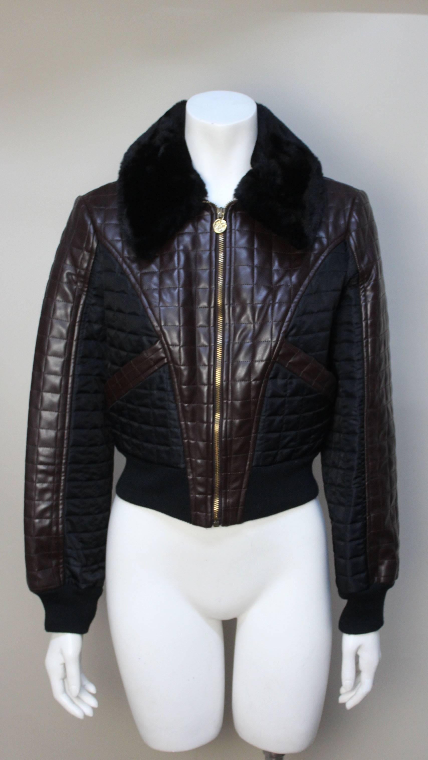 Cropped bomber jackets were all the rage in 1990's fashion and their time has returned. This quilted vinyl style is very on point. It has great details. The body is in a rich brown vinyl with black nylon quilted inserts above the slash pockets. The