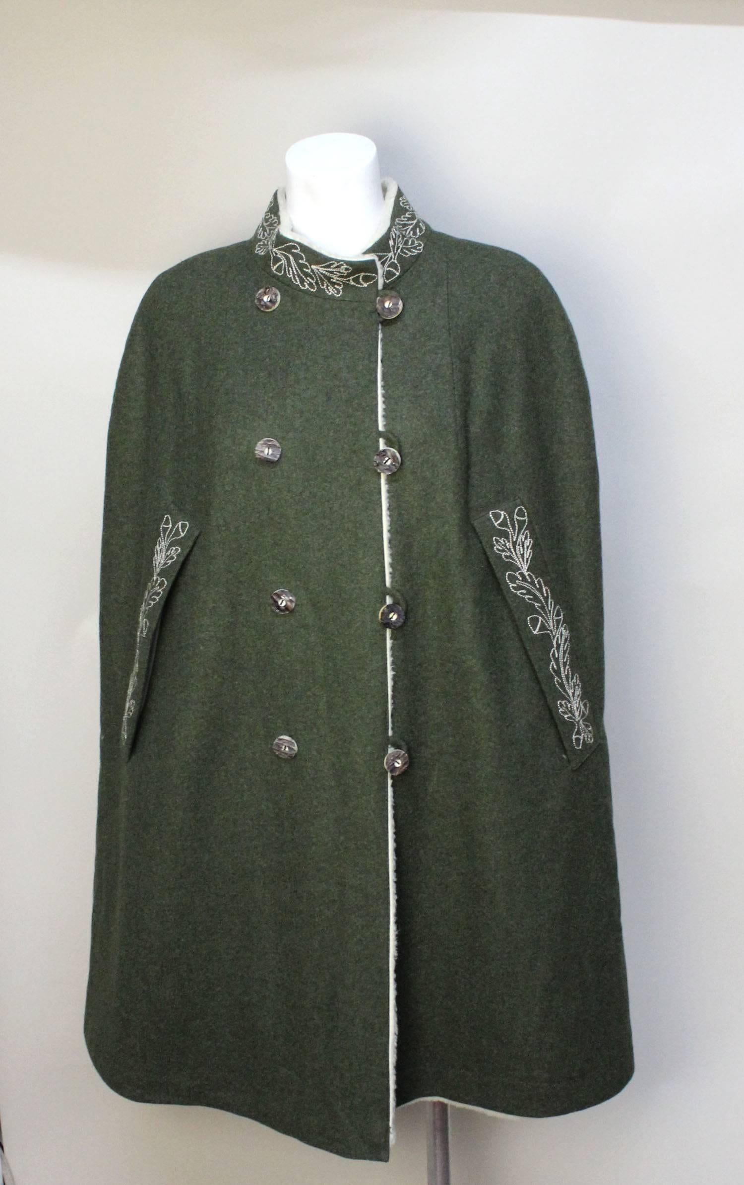 This classic vintage Tyrolean style cape has wonderful lines and works beautifully with current fashion. There is striking embroidery along the collar and armholes. It is double breasted with carved horn buttons. It is fully lined in a creme sheared