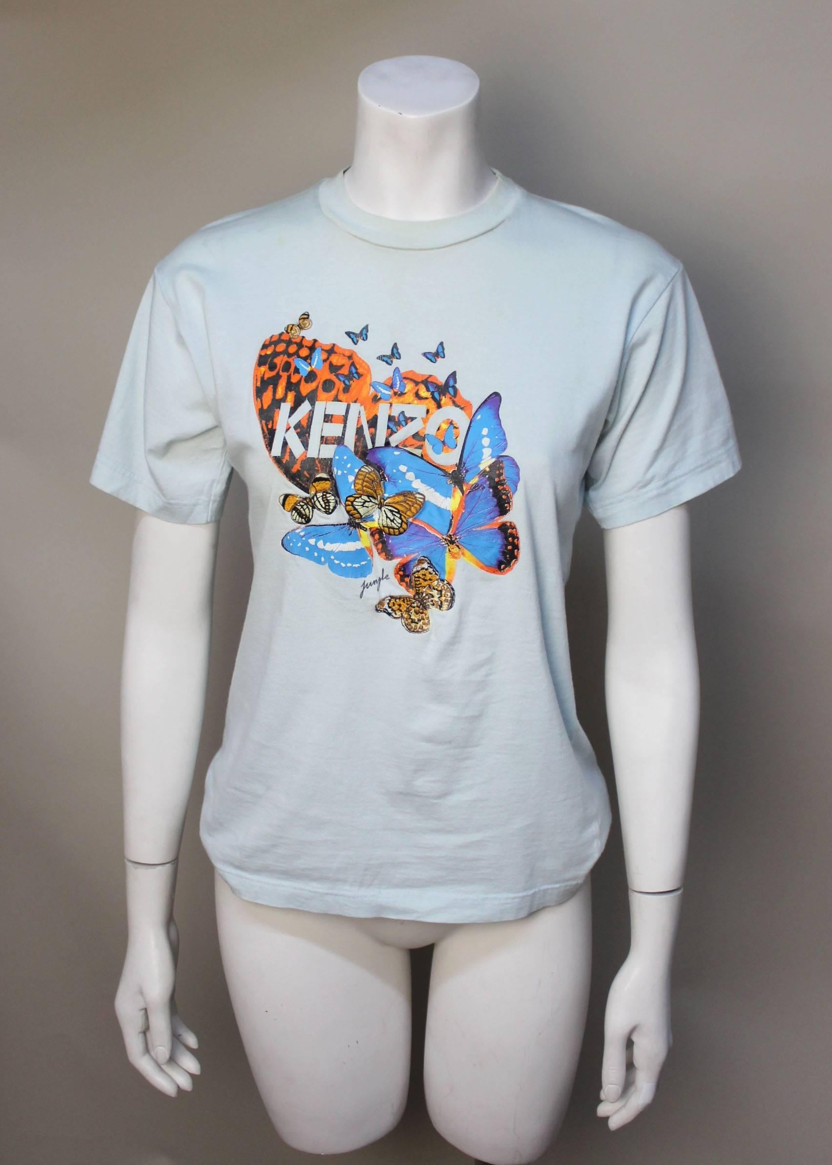 Kenzo introduced his Jungle line in the mid 1980s. It appealed to a younger Kenzo fan. This early tee has a vibrant, colorful design of butterflies silkscreened on it with the clever addition of embroidered patches. Kenzo was known for his love of