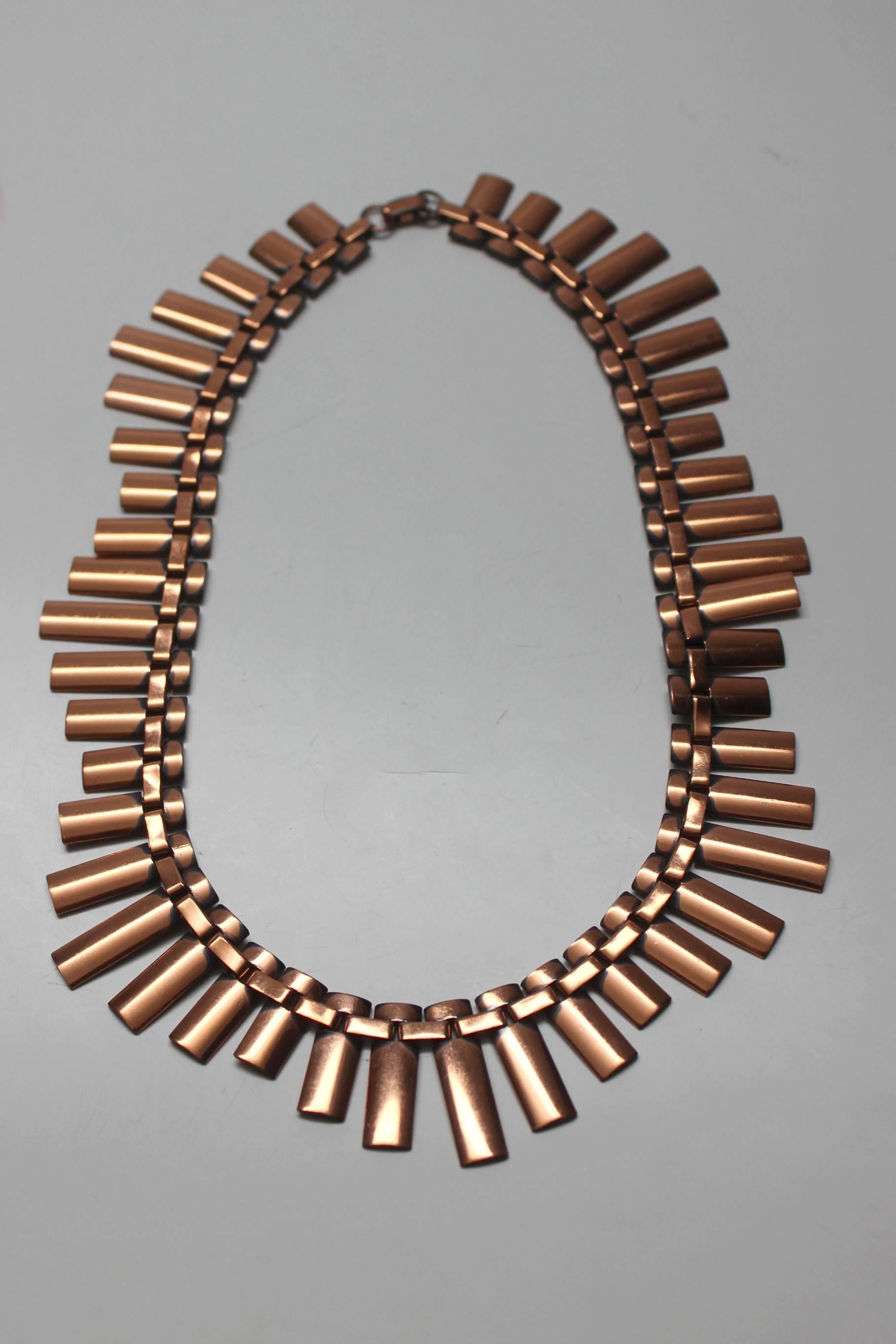 This 1950's copper choker is beautifully designed. It has vertical discs of various sizes threaded onto a copper link chain. It is a very chic piece in a 1950s modernist style when copper jewelry was all the rage. The clasp is signed Renoir, the