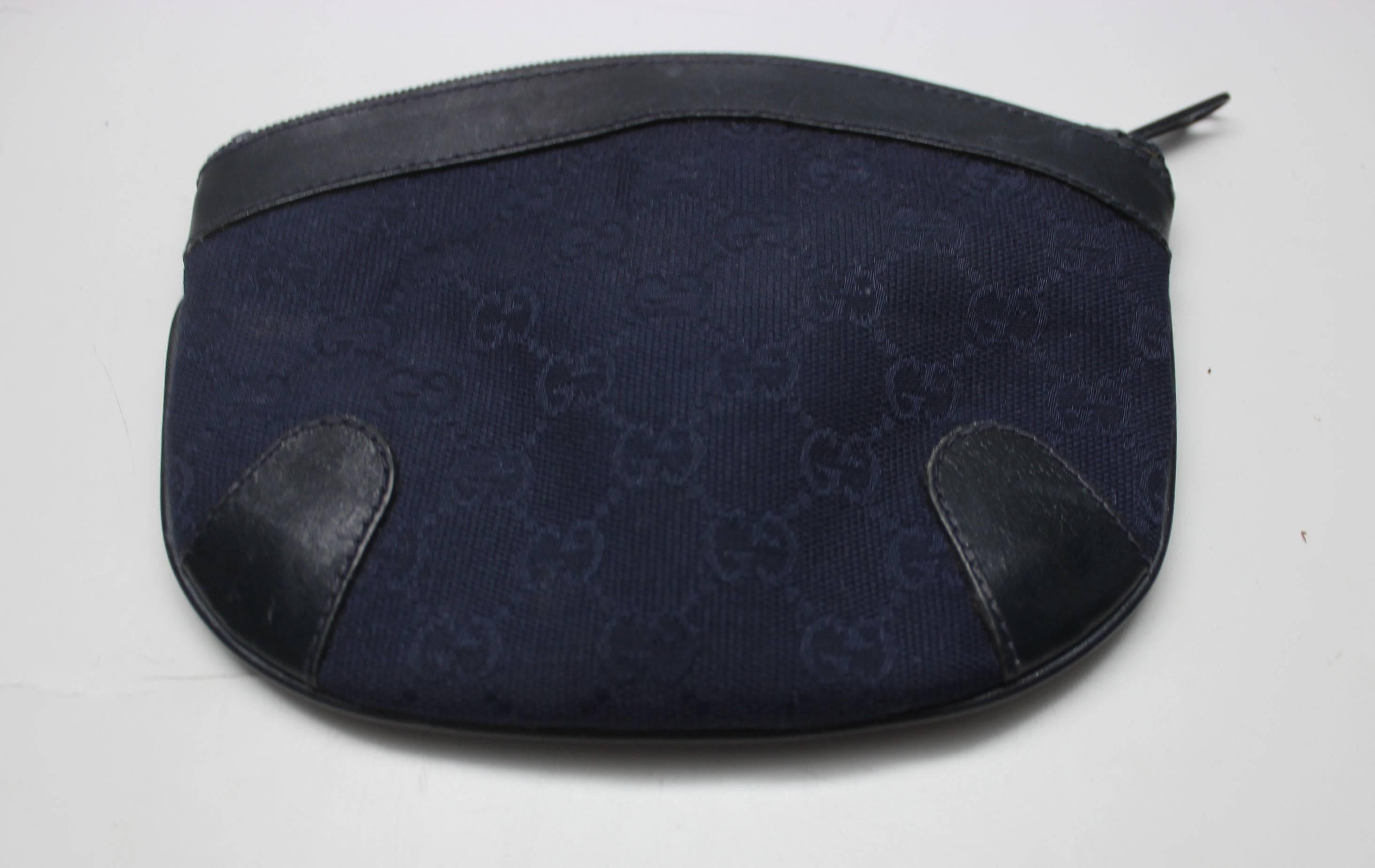 This vintage navy Gucci canvas cosmetic bag is super chic and versatile. The dark monogrammed canvas is durable, has reinforced corners, and a top zipper. The inside has the Gucci label and light blue plasic lining. 
This bag can be used for make