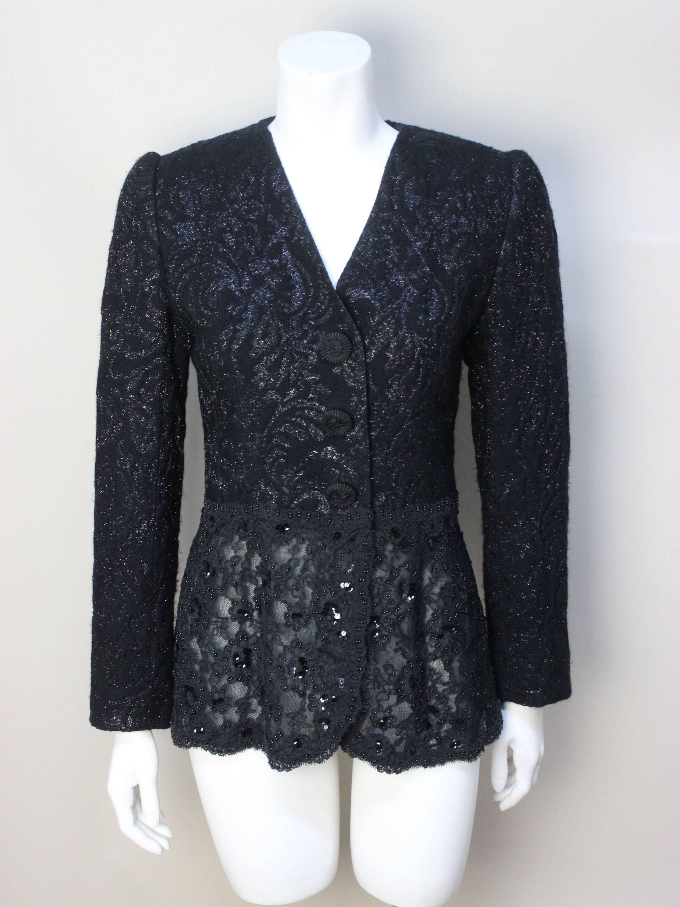 This beautiful 1980s evening jacket ws sold in the designer penthouse of Miss Jacksons, an upscale store in Tulsa. The top half of the jacket is constructed of a metallic wool with a subtle leaf pattern. The bottom half is fine beaded lace. It would